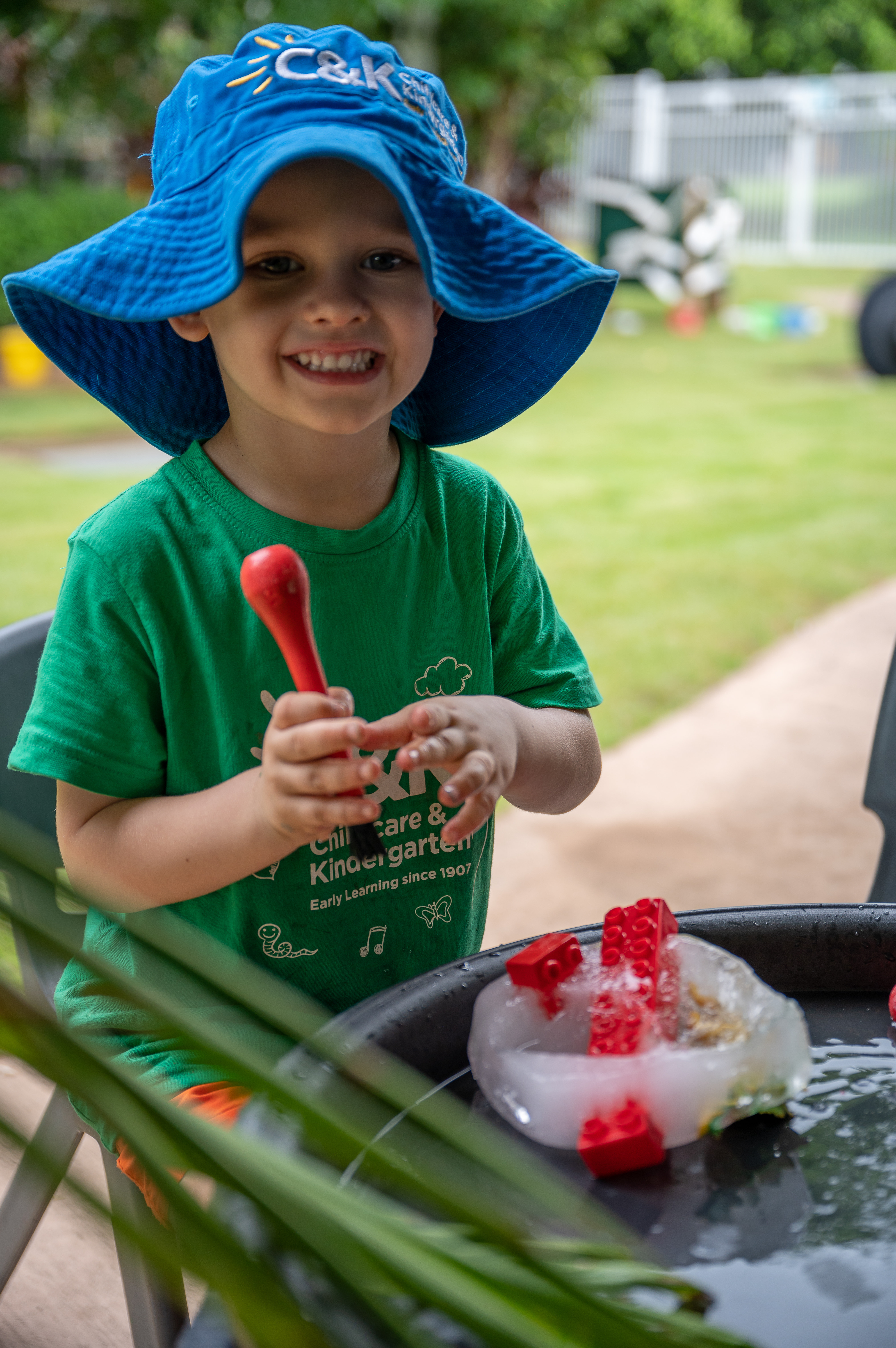 Young boy playing with ice cube outside