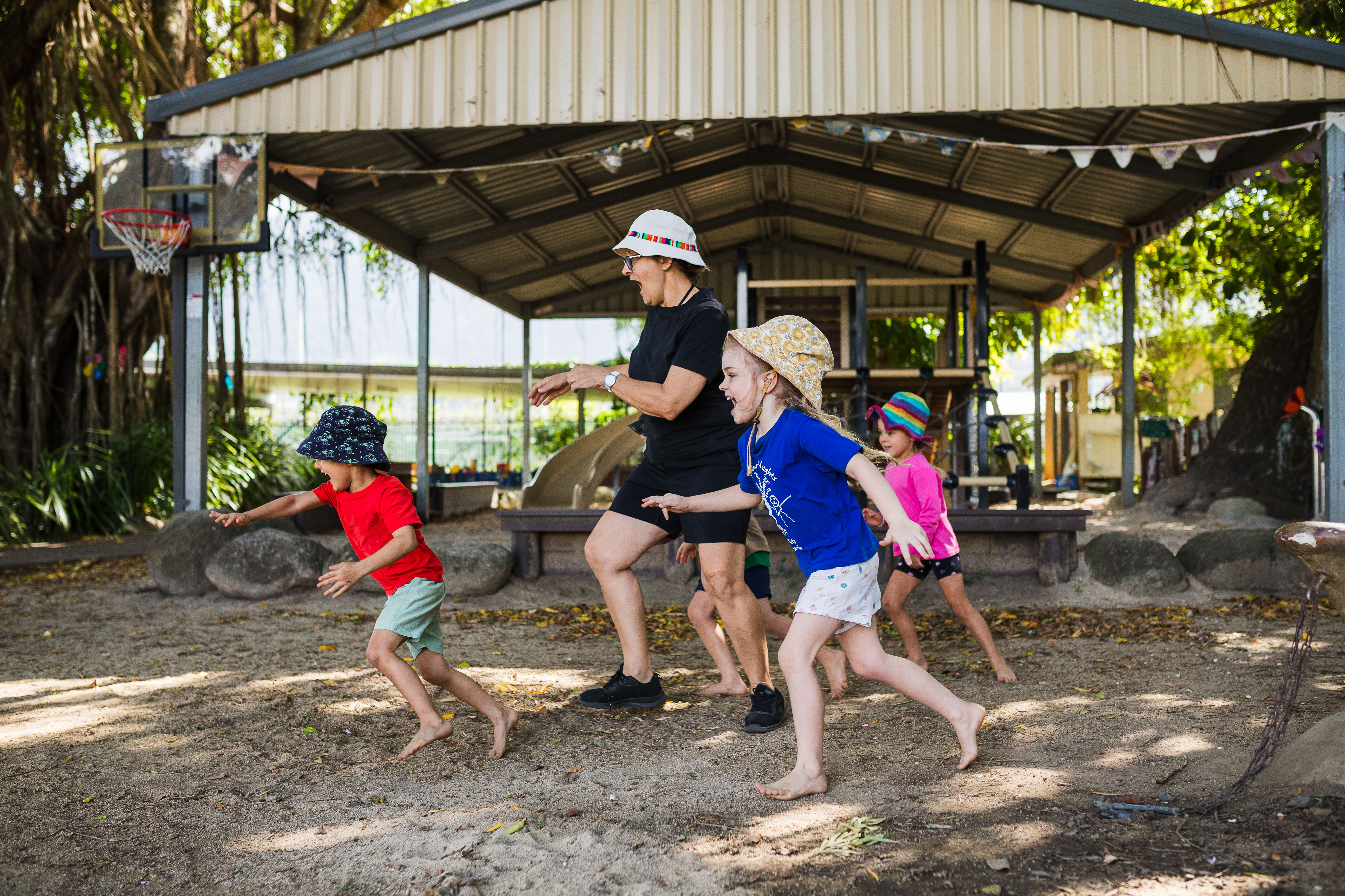 Educator and children running and playing