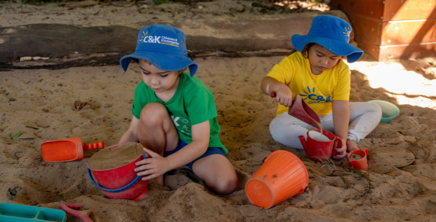 Two kindy children playing in sandpit