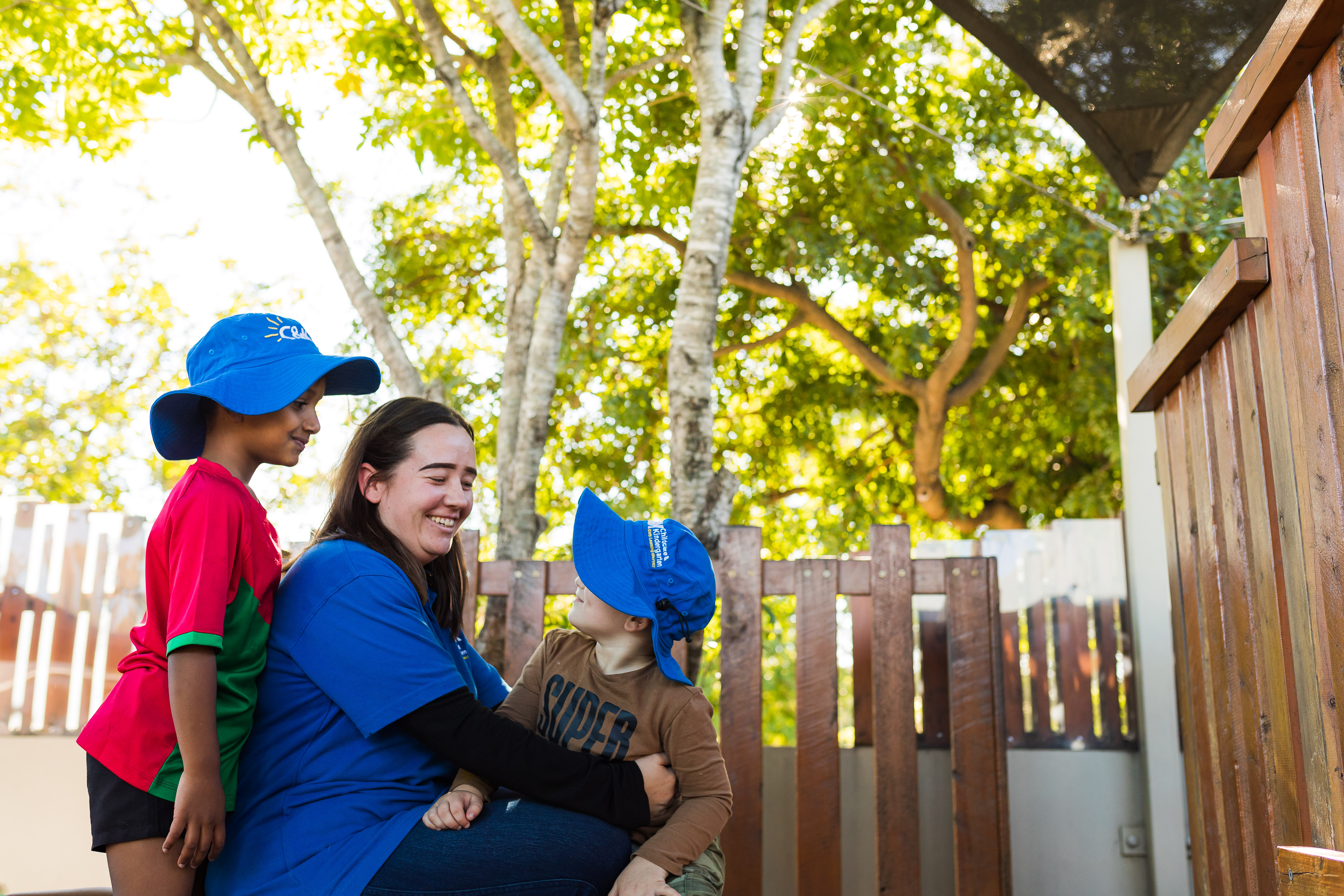 educator playing outside with two children