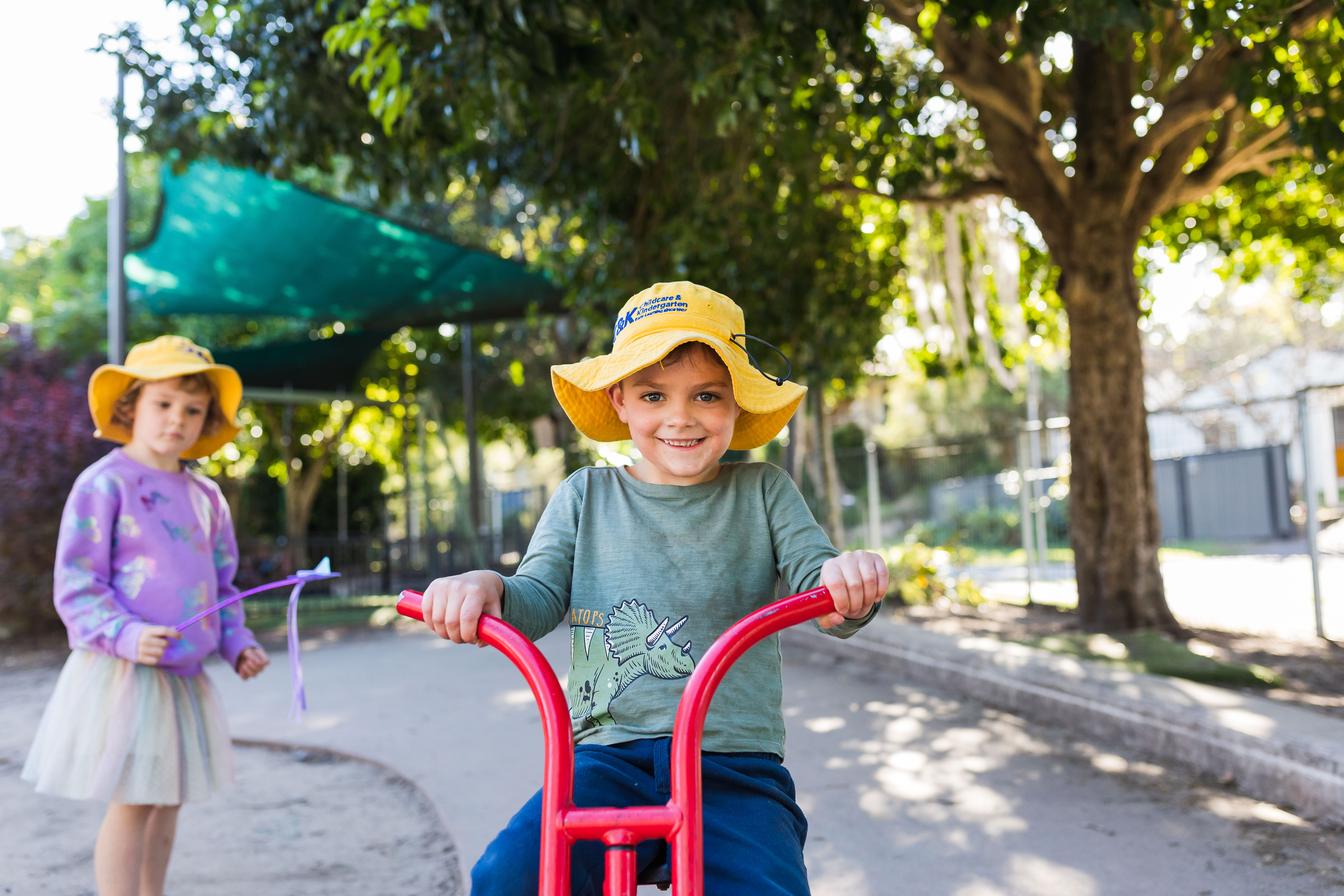 two children outside one is on bike