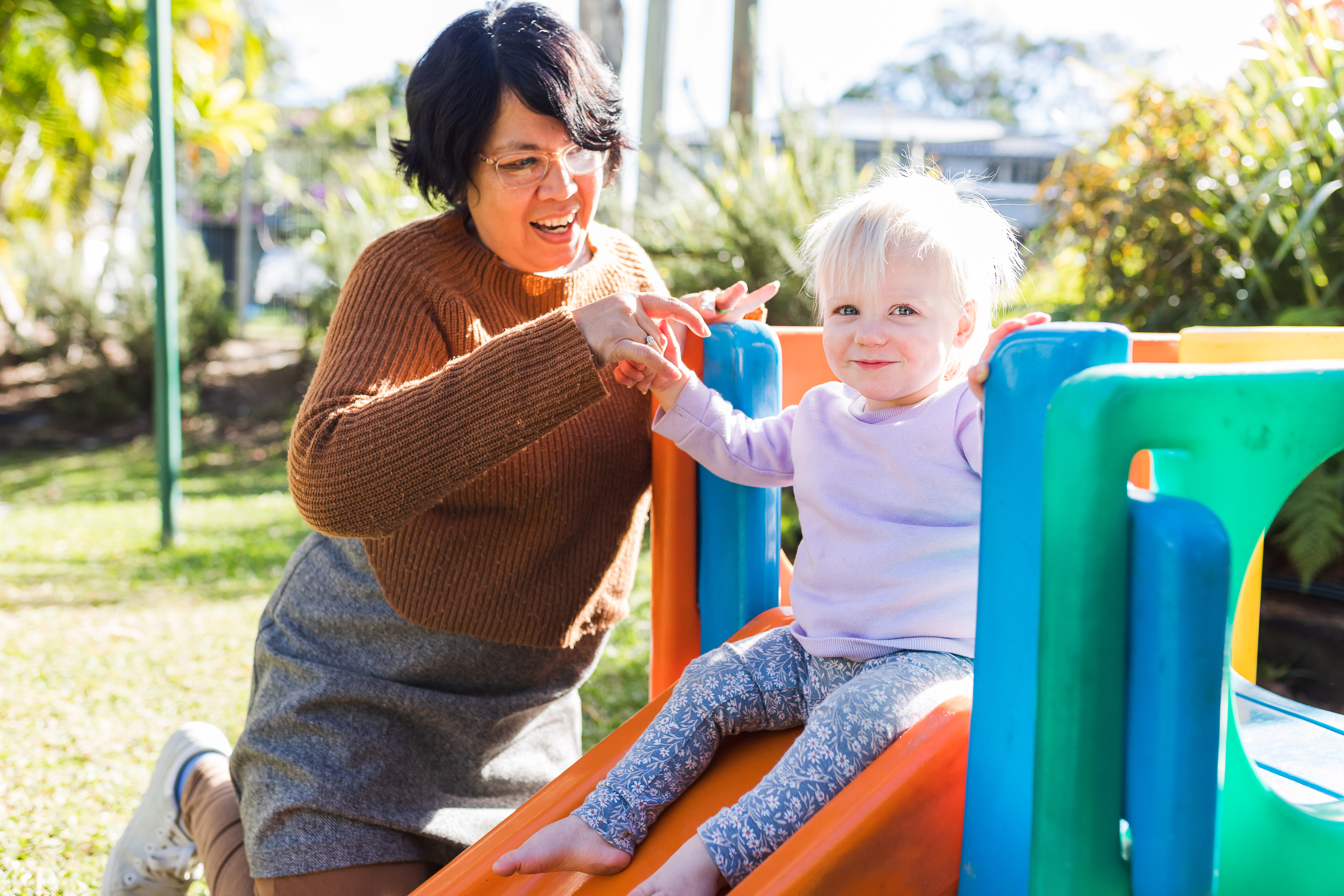 Educator and toddler outside playing