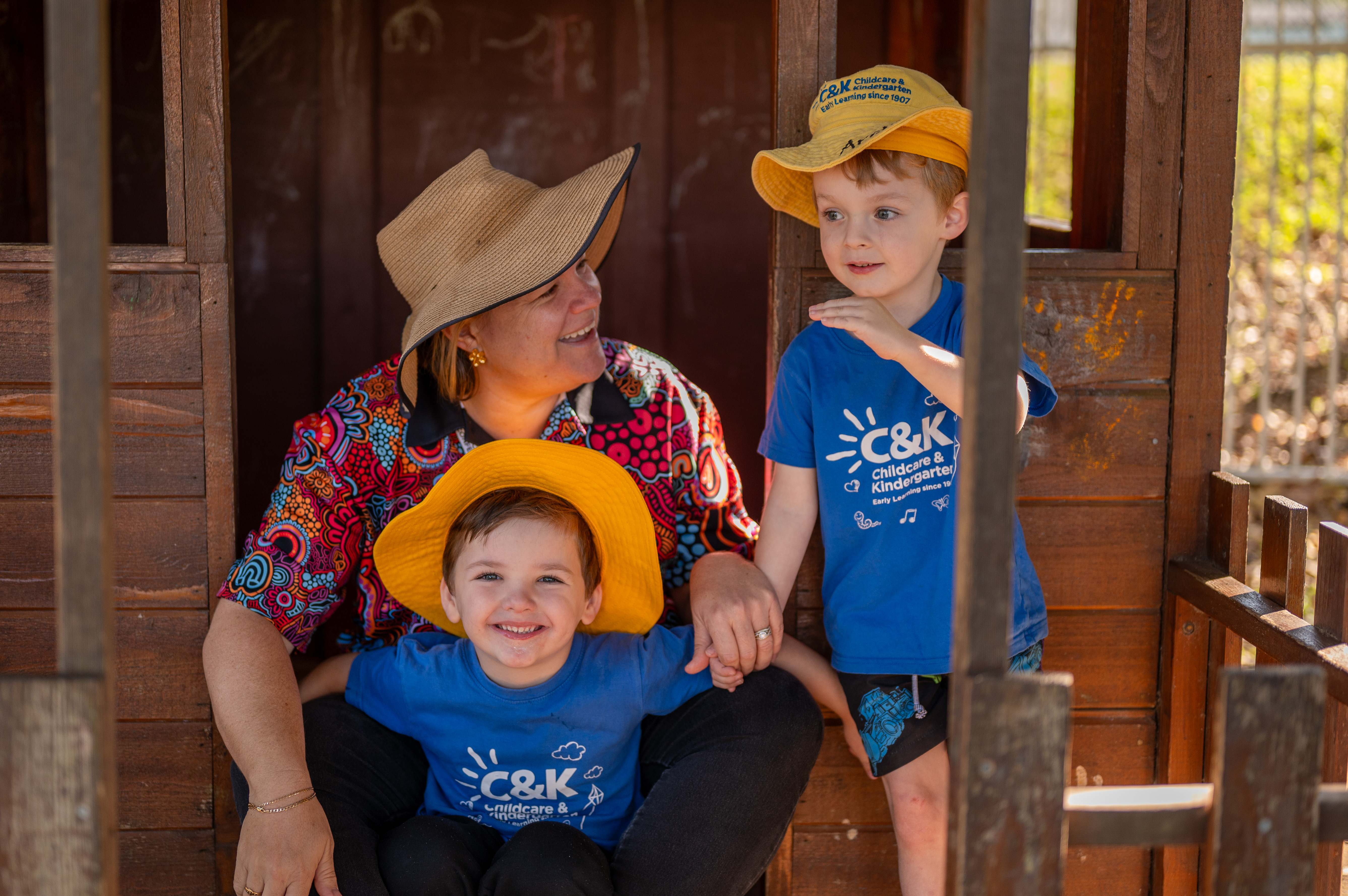 educator and two children outside smiling