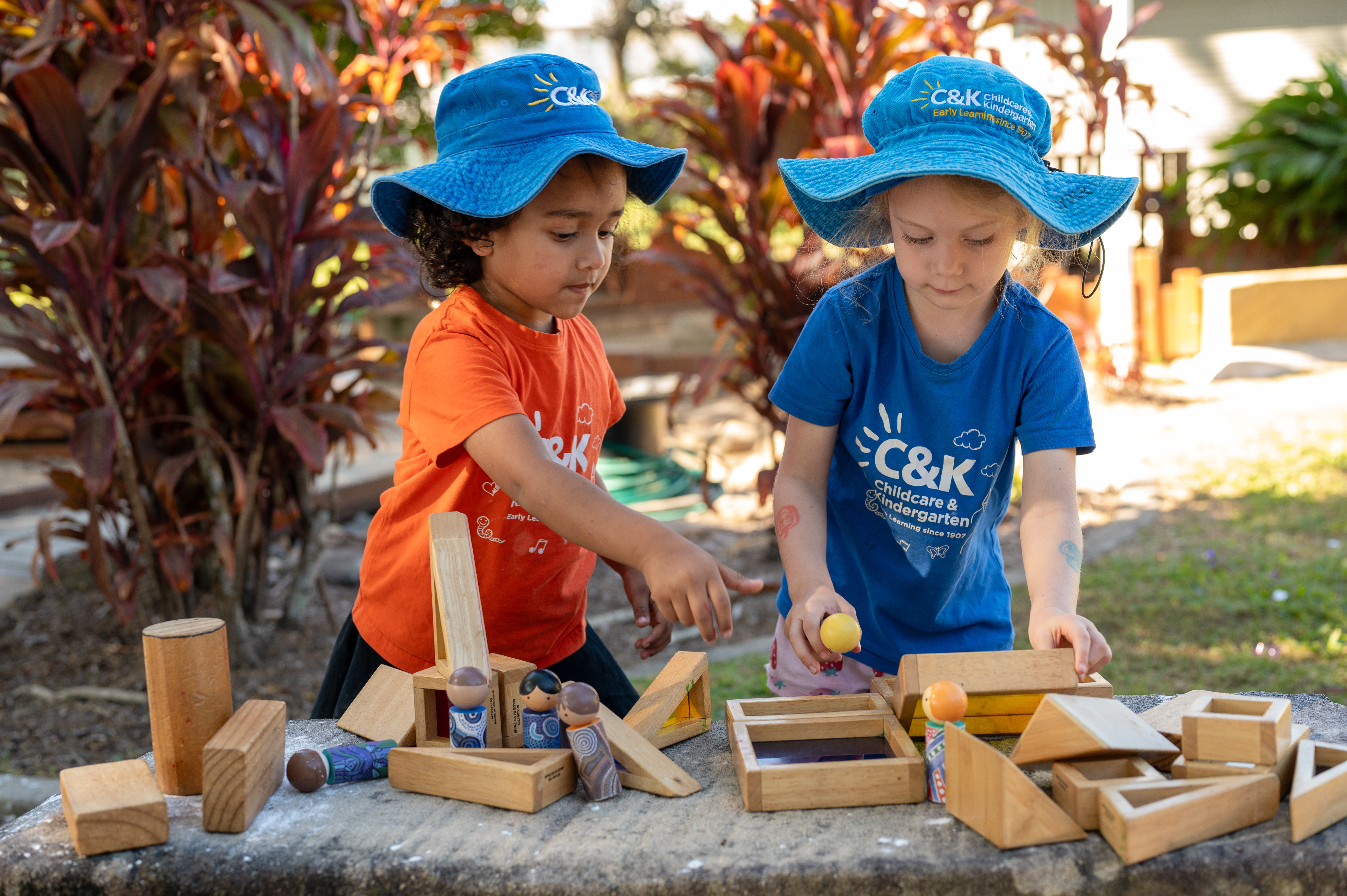 Two children paying with blocks outside