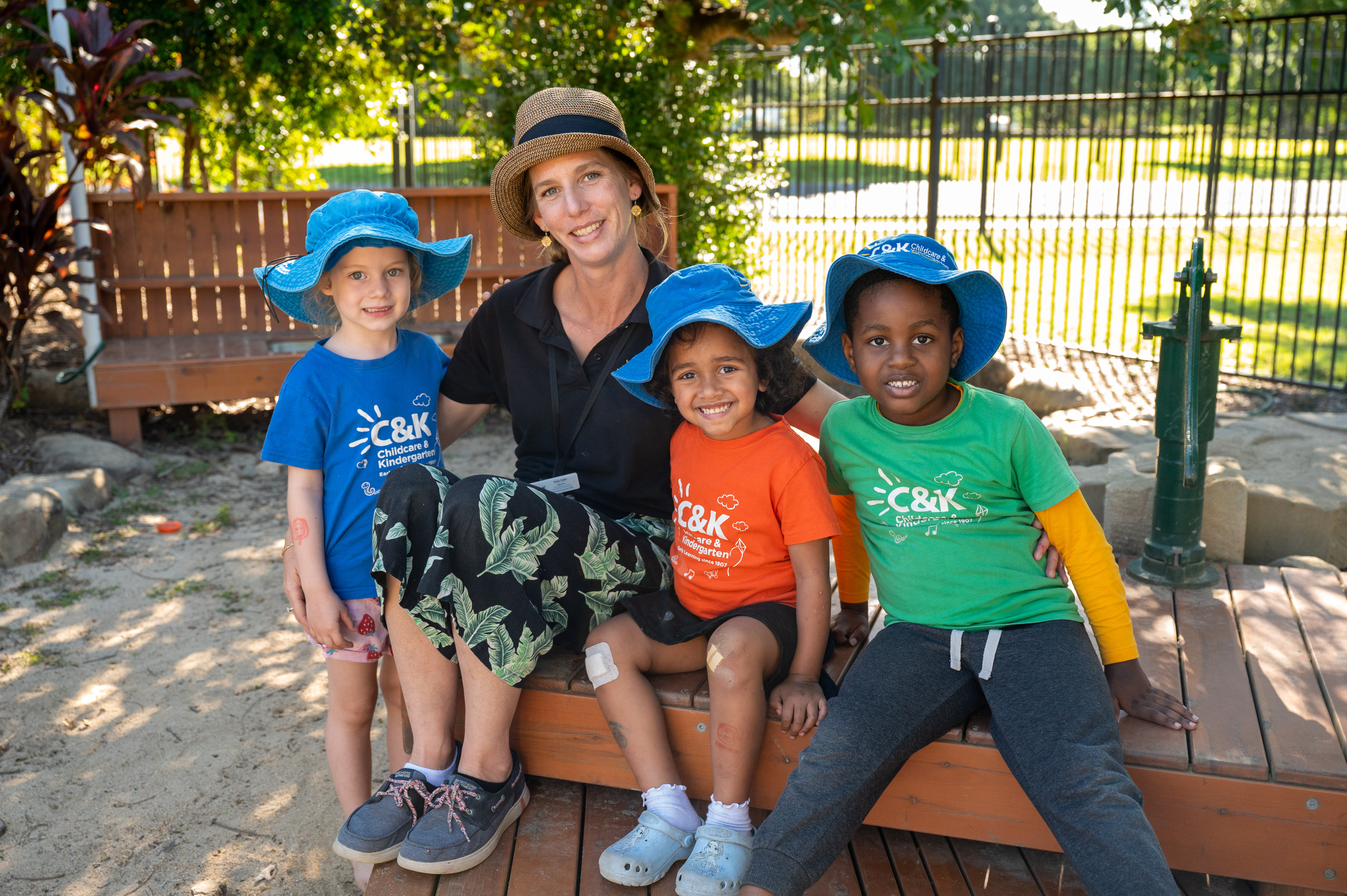 Educator and three children outside smiling