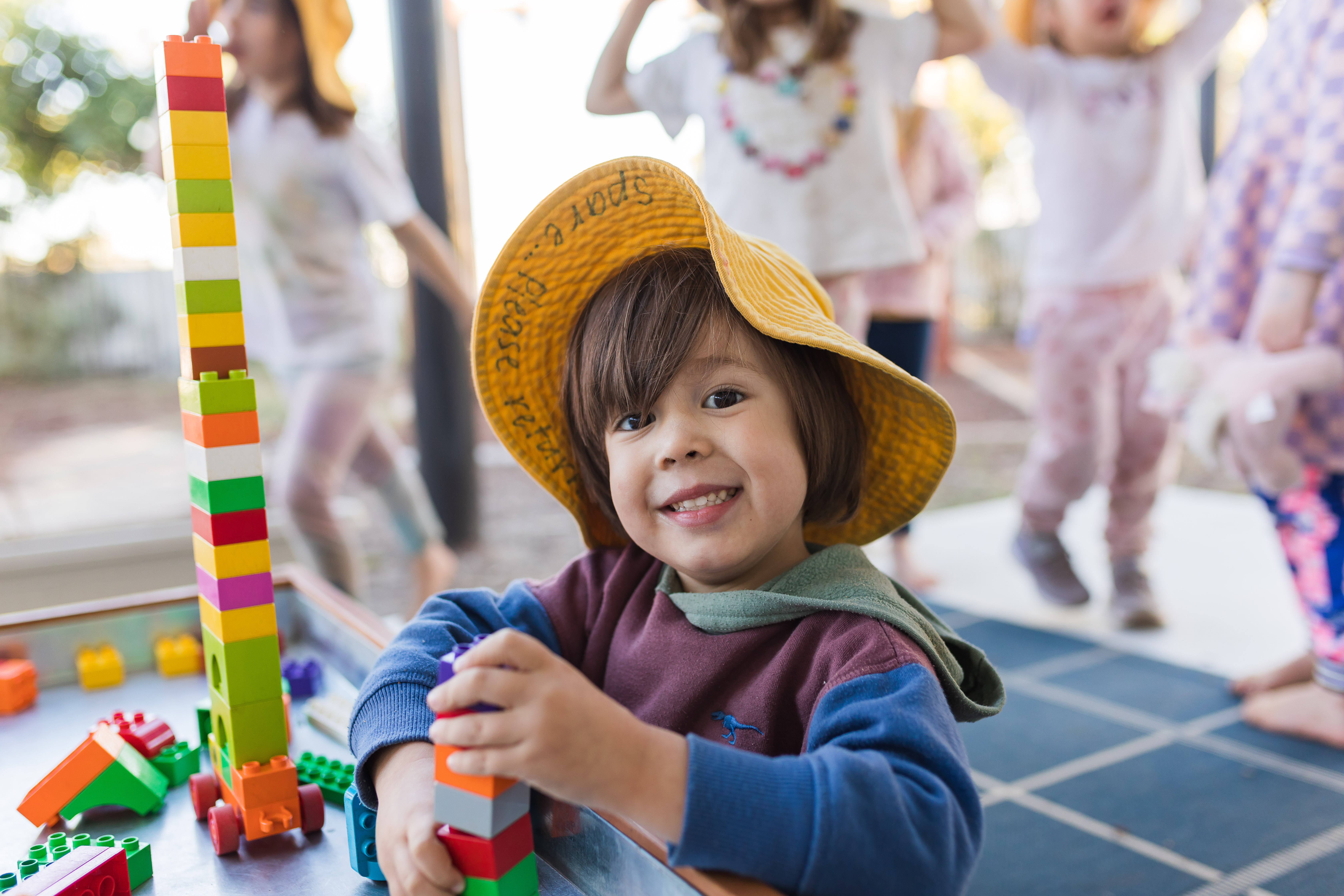 child outside building with blocks
