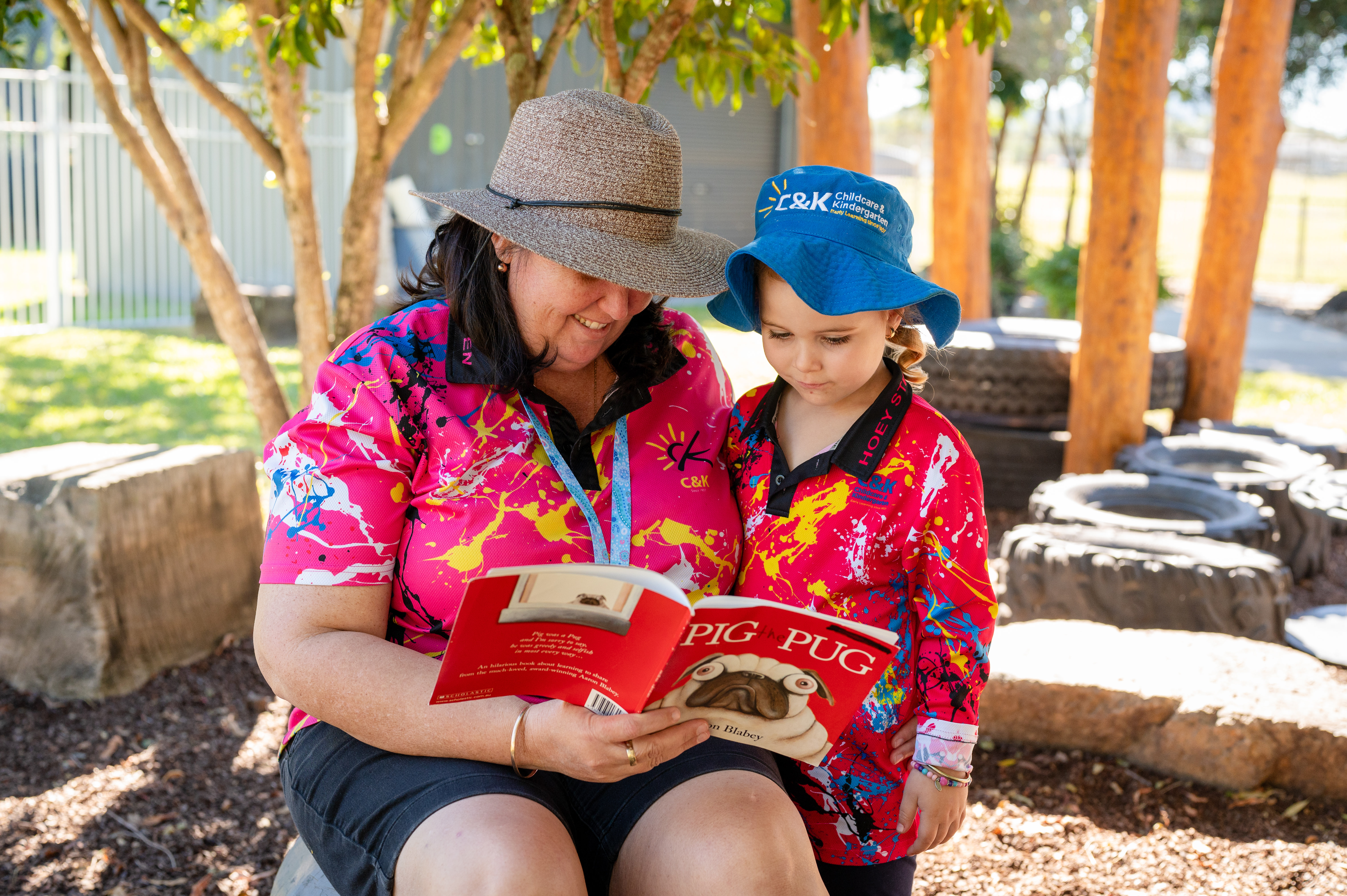 educator reading child book outside