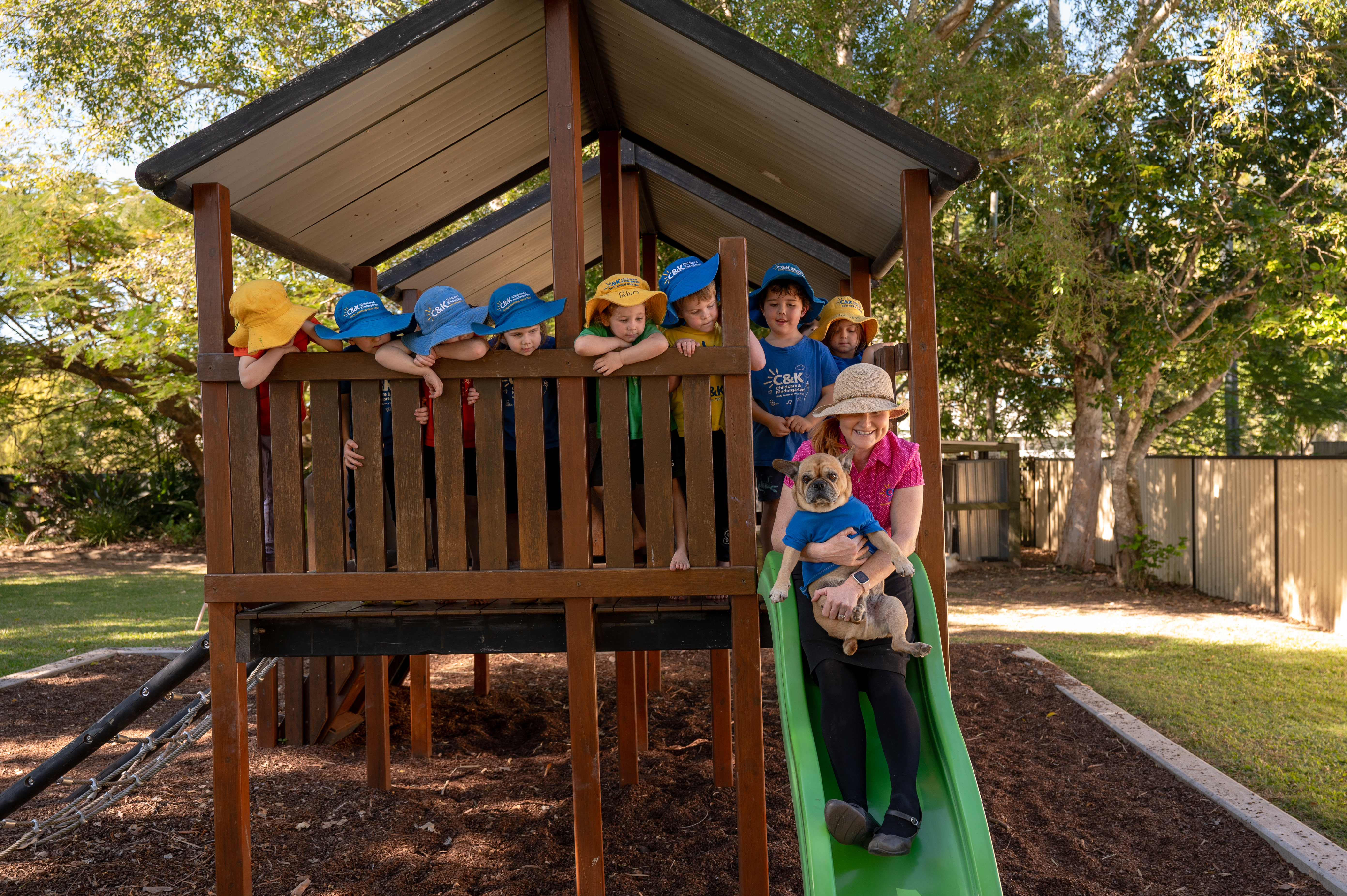 Educator with children going down slide