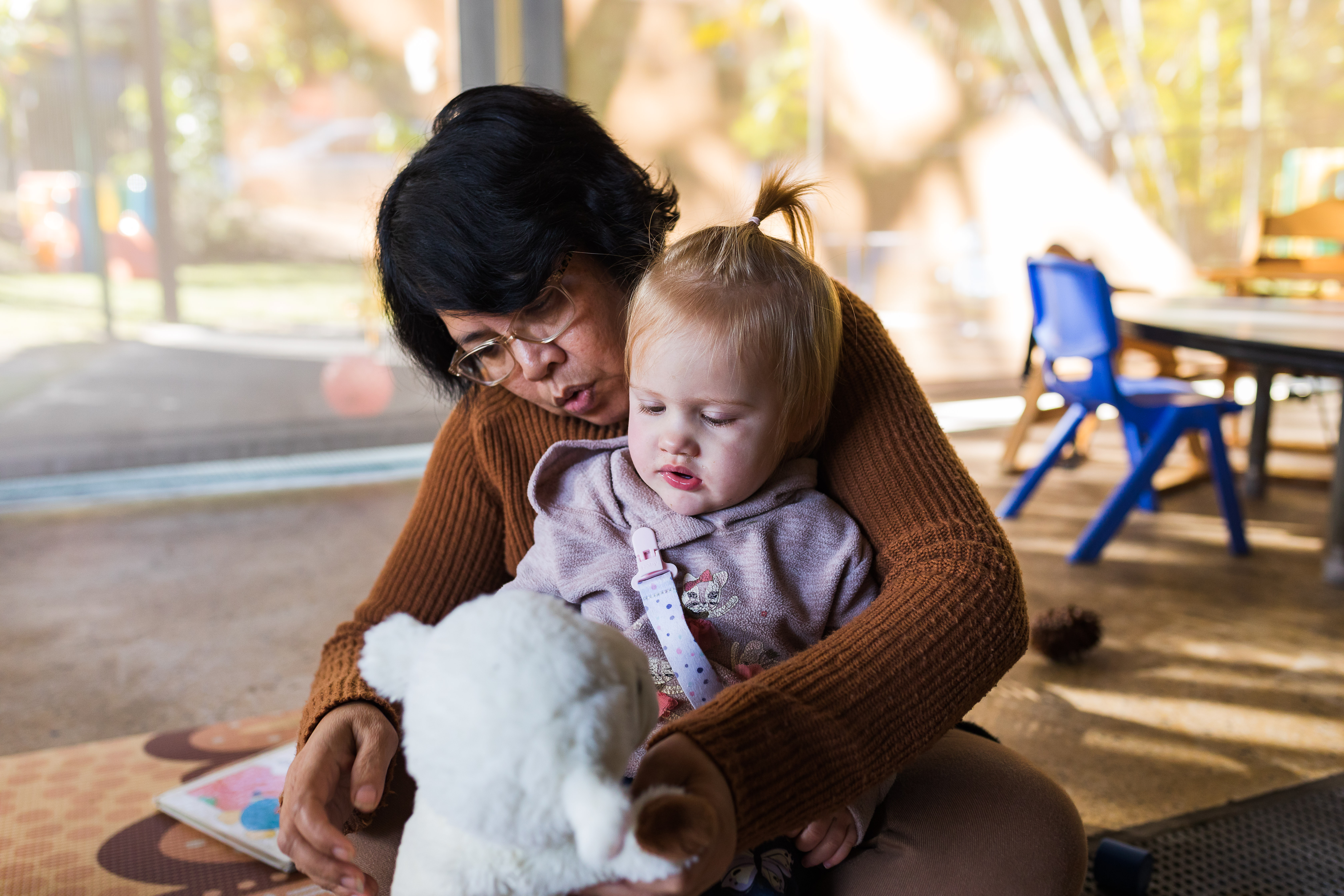 Educator cuddling toddler