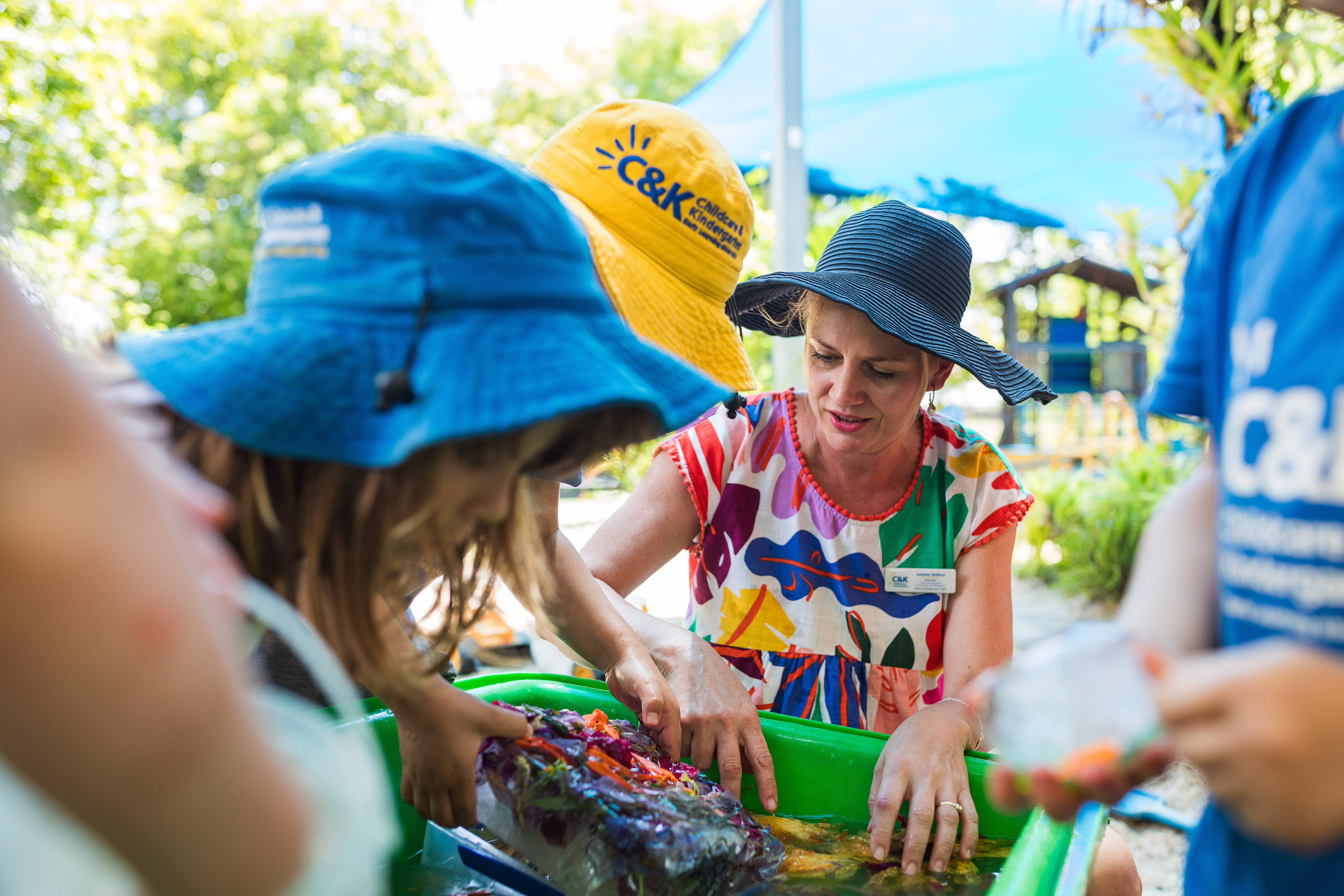 Teacher with kindy children doing water play