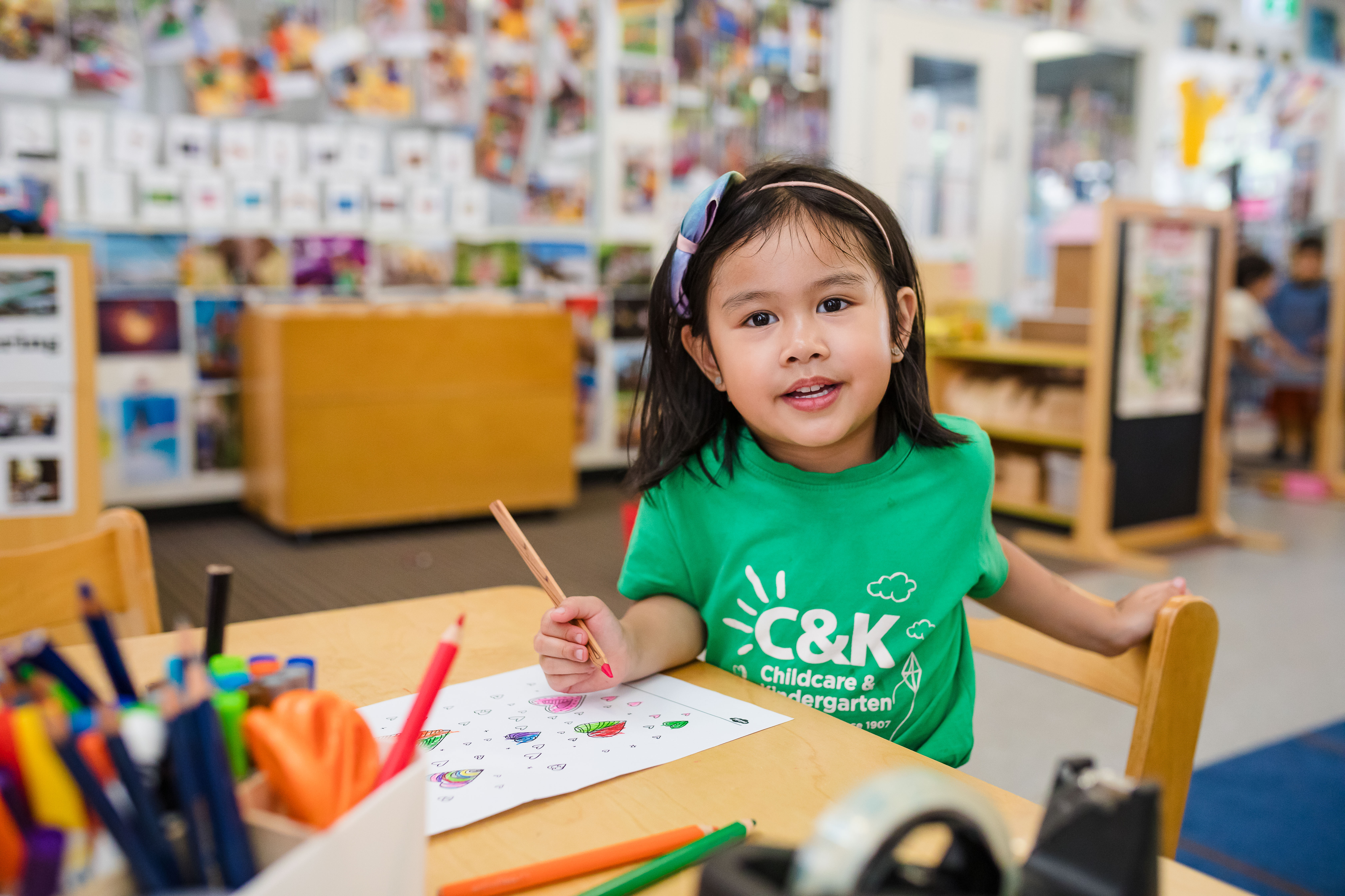 Kindy child writing at inside table