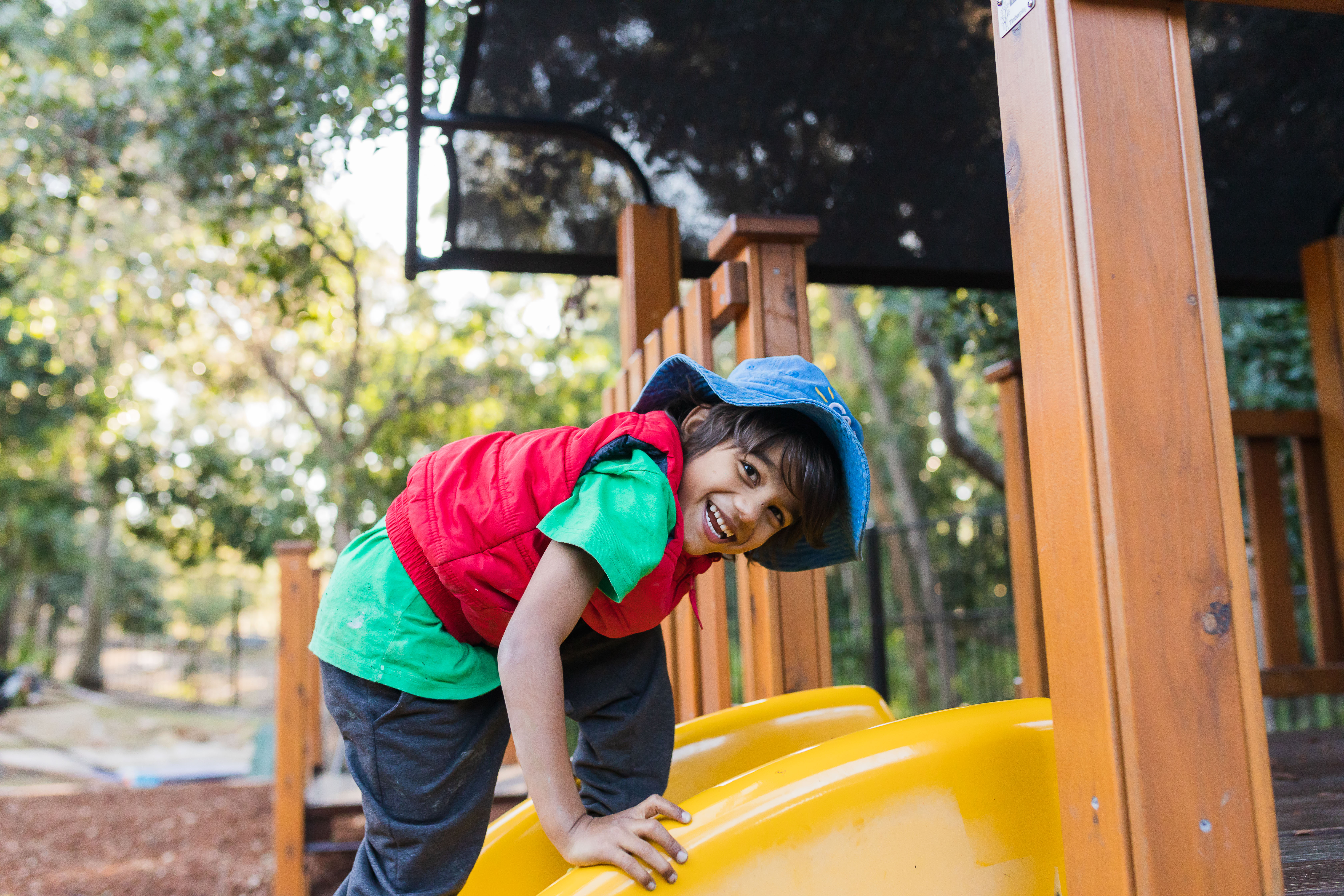 Smiling child climbing up slide