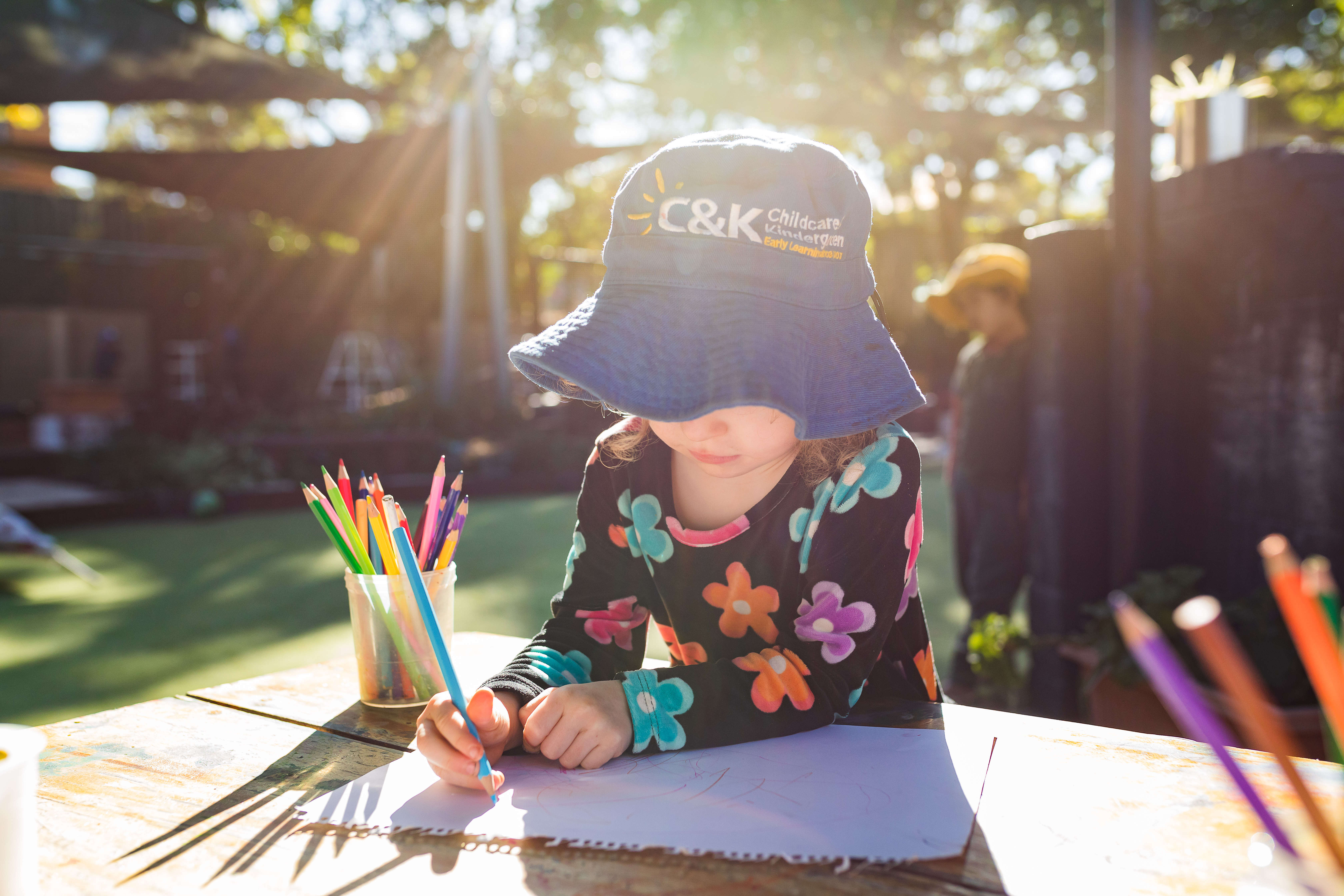 Child drawing outside in the sunshine