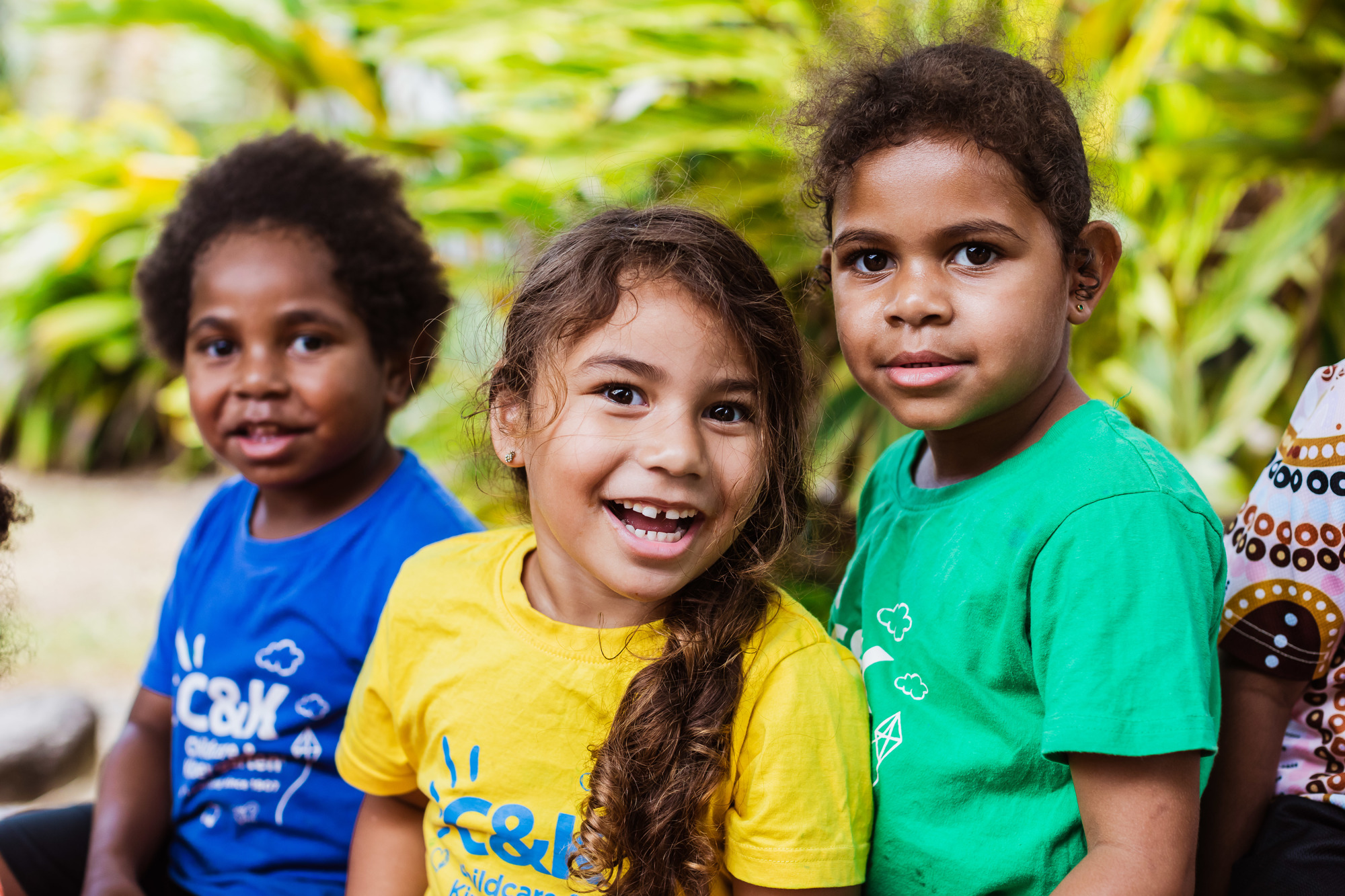 Three kindy children smiling outside