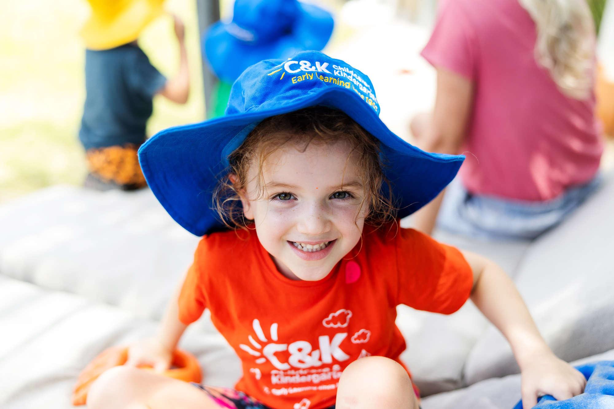 Child smiling wearing hat outside