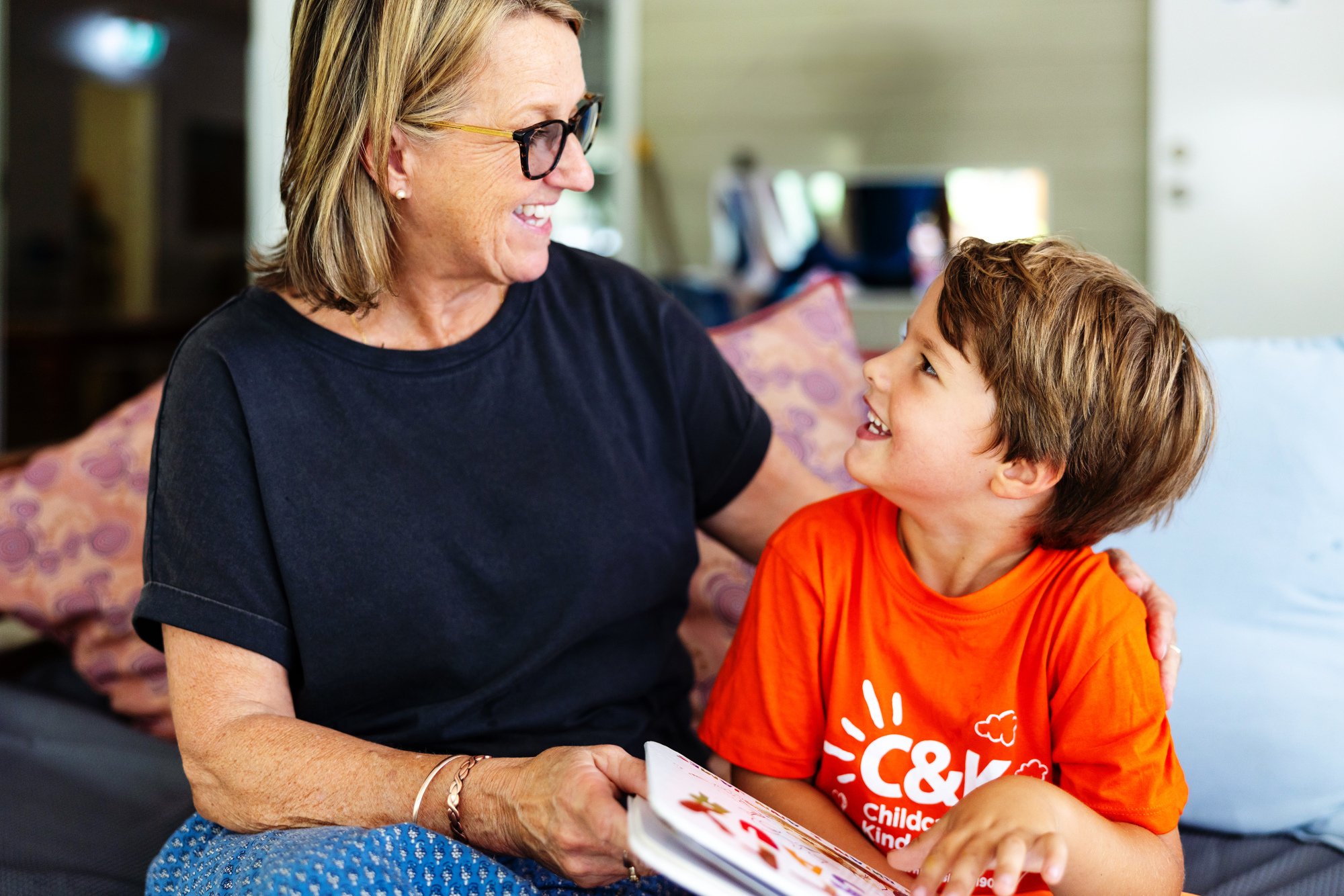 Teacher and children smiling and reading together