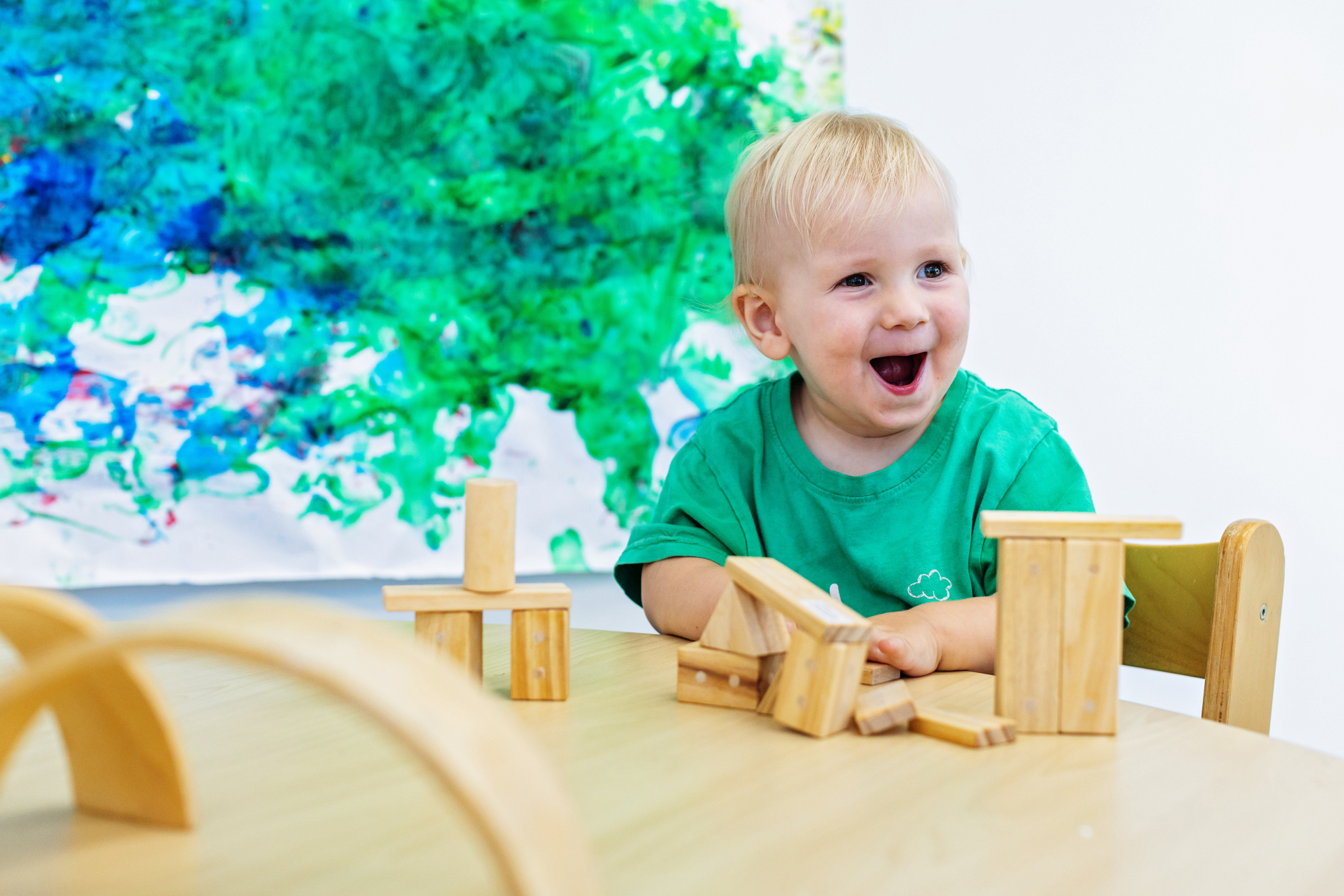 Toddler smiling at table with blocks