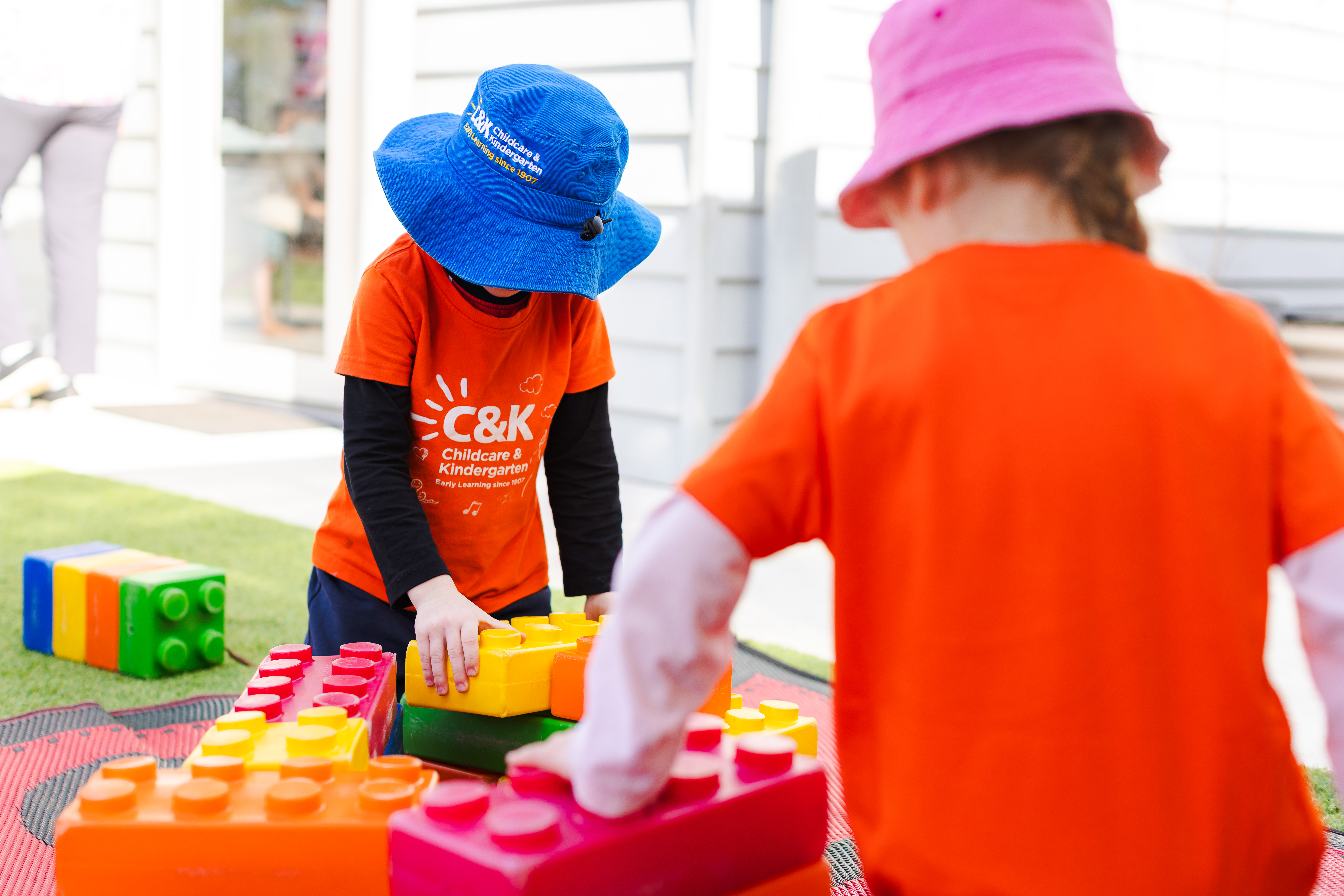 Children playing outside with colourful bricks