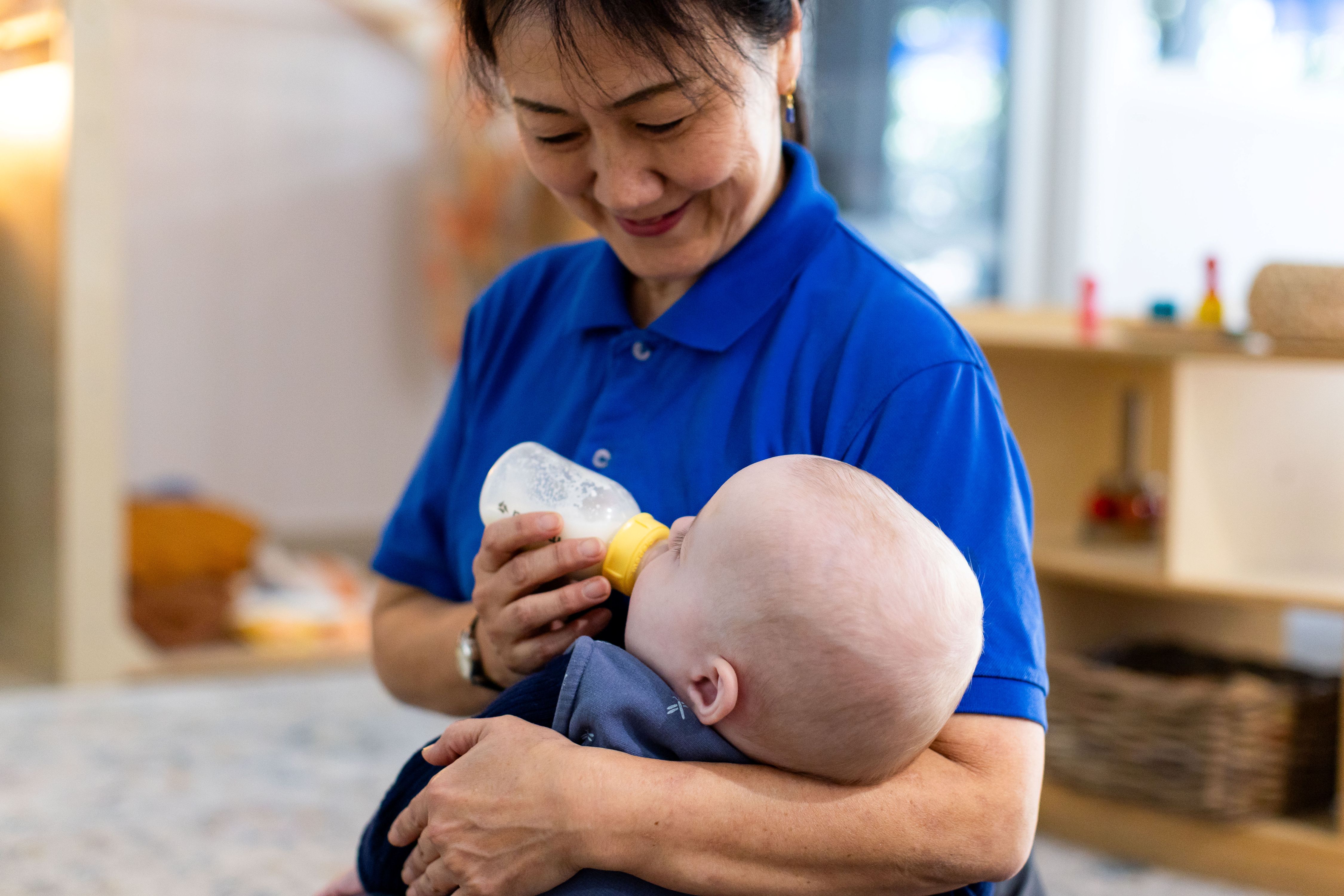 Educator feeding an infant