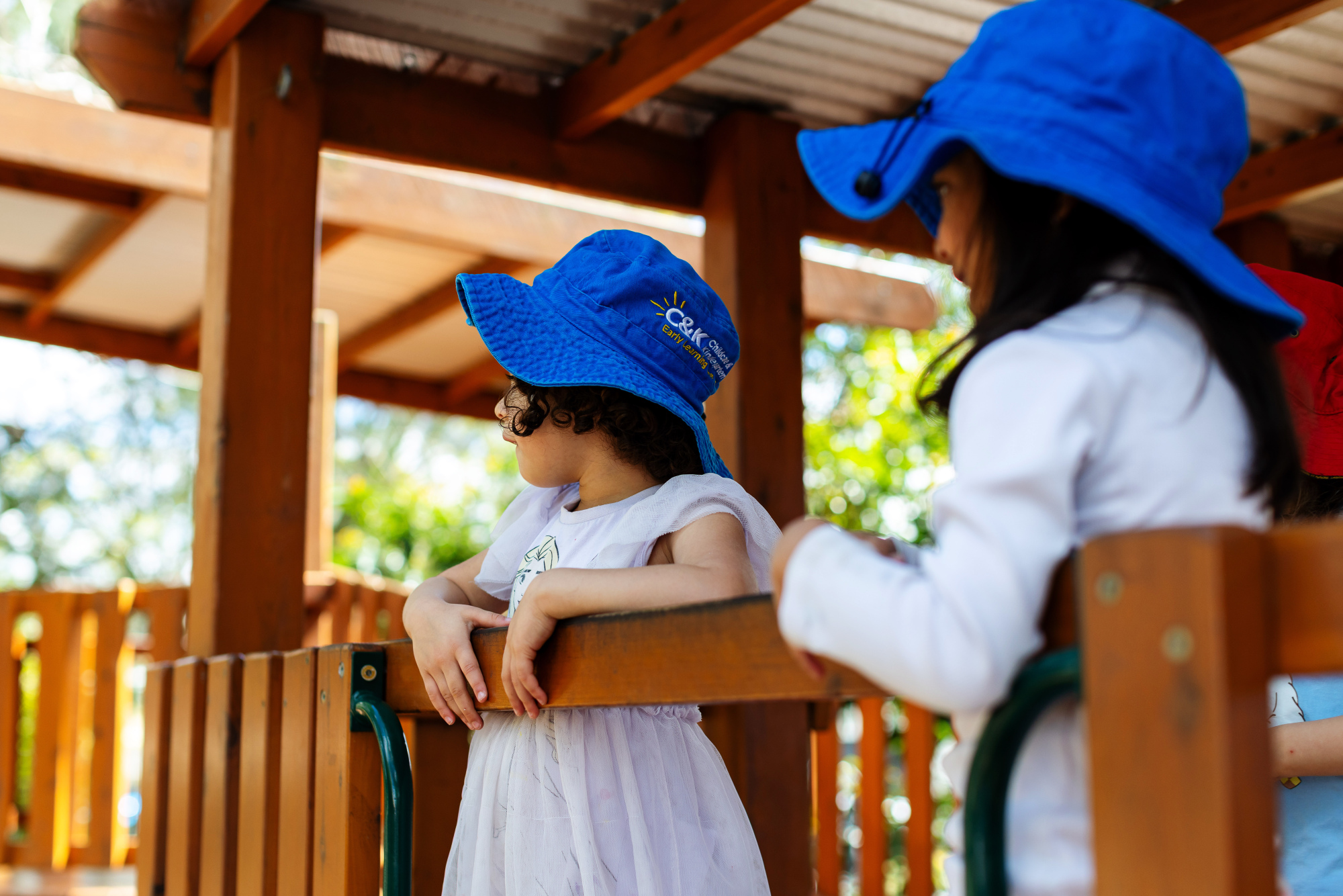 Two children outside on the wooden playground
