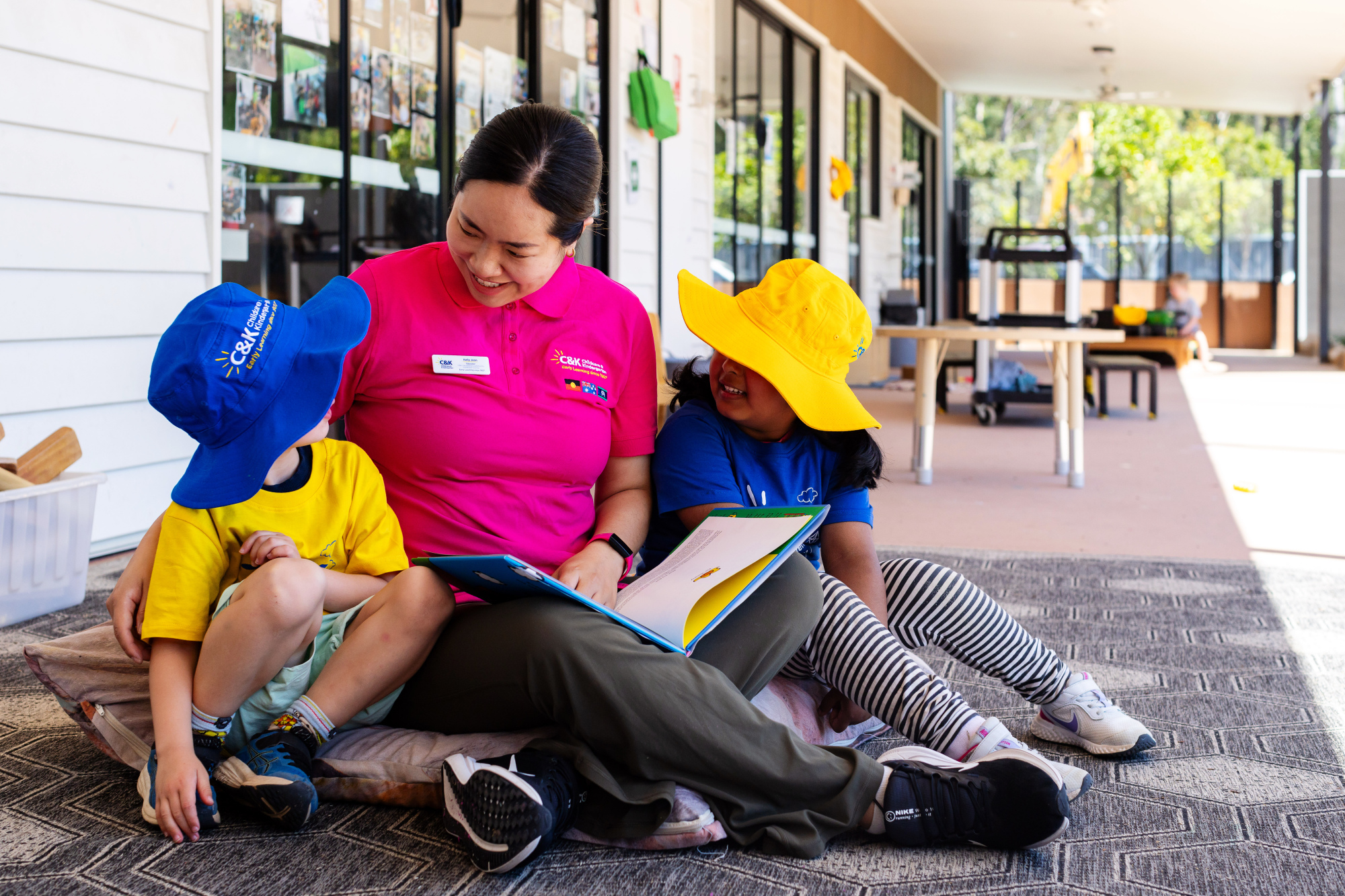 Educator reading to two kindy children