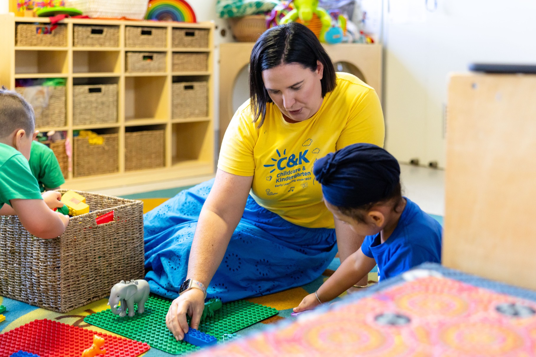 Educator and child working together with Duplo