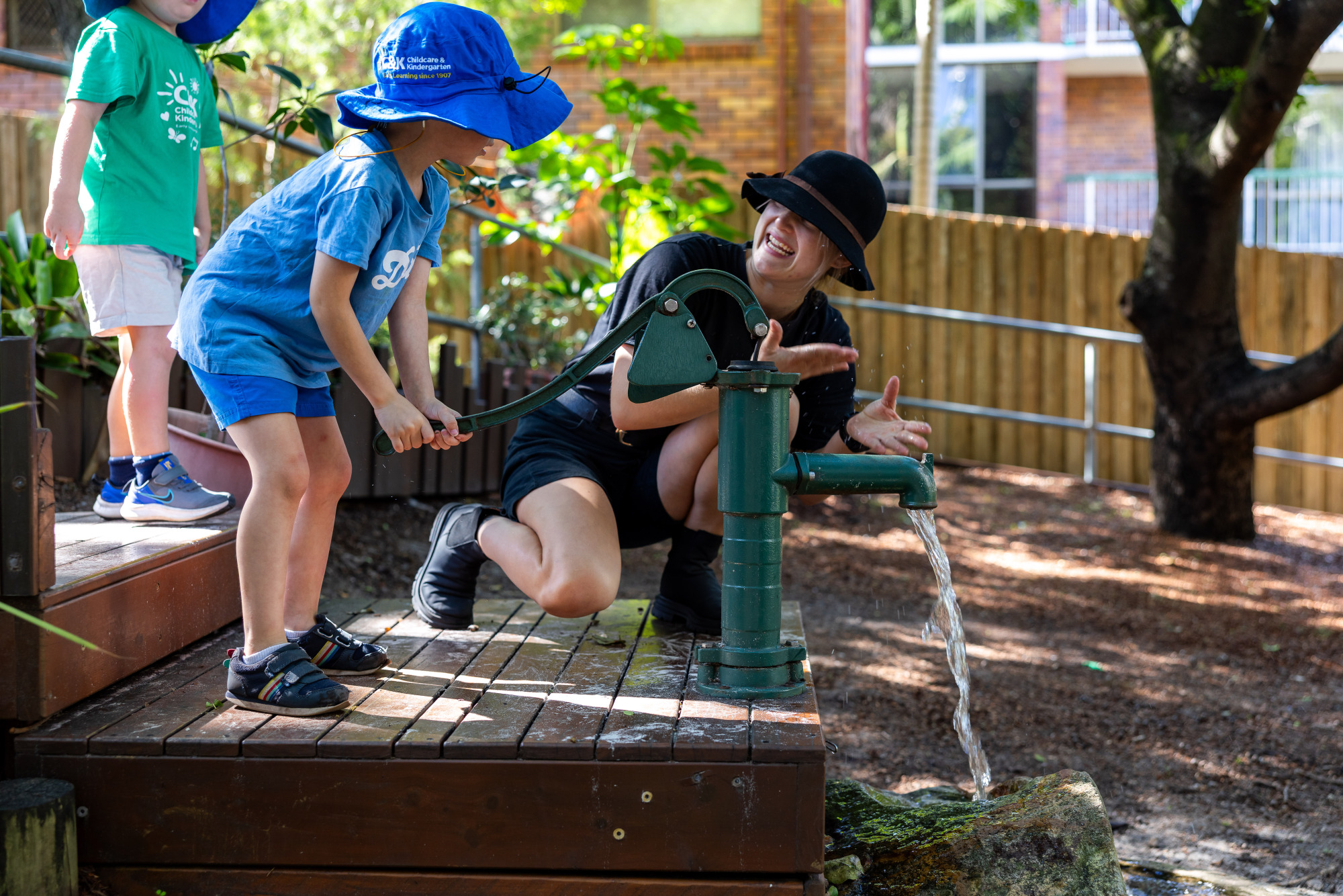 Kindy children playing outside with educator