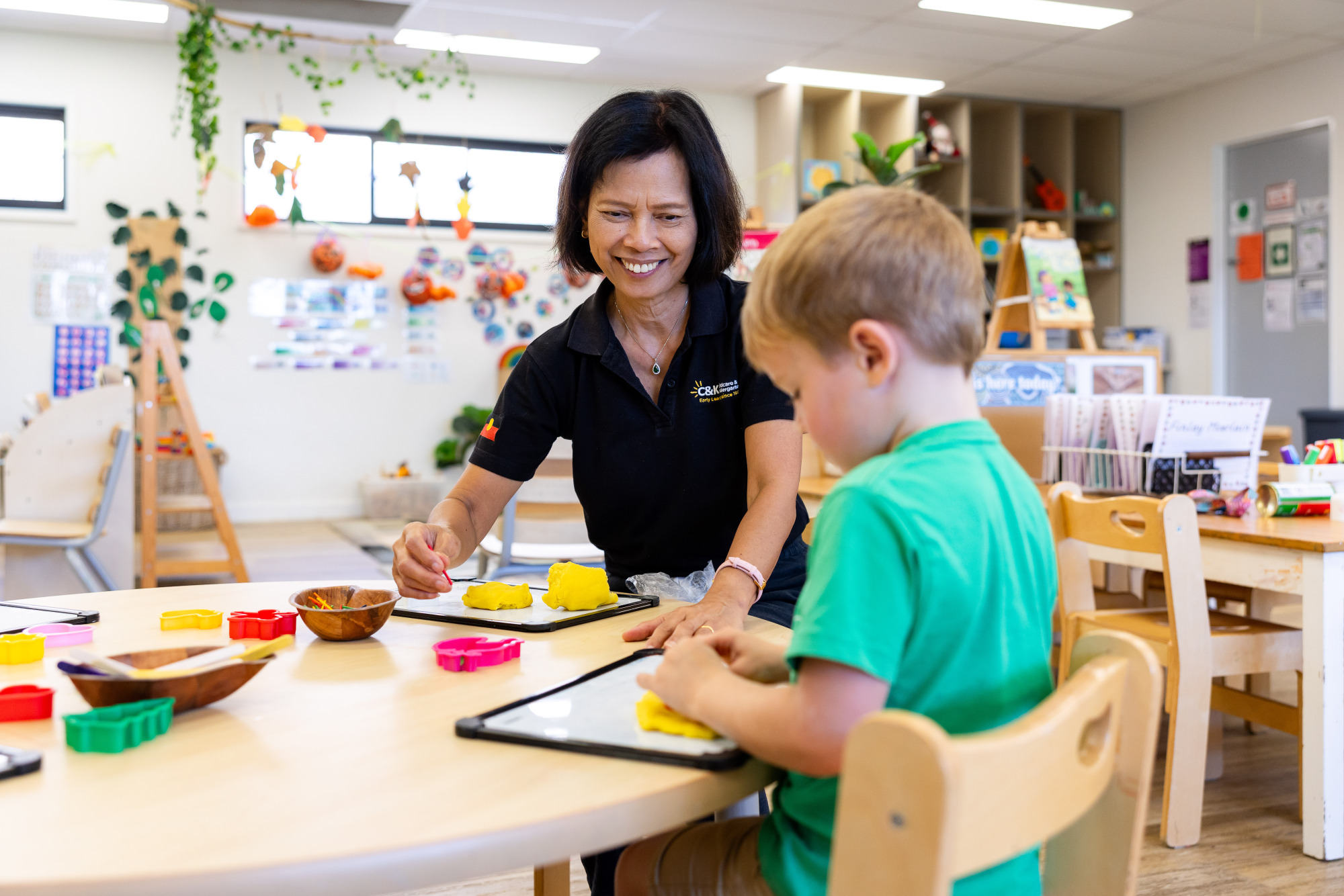 Educator engaging with child inside a light and bright centre