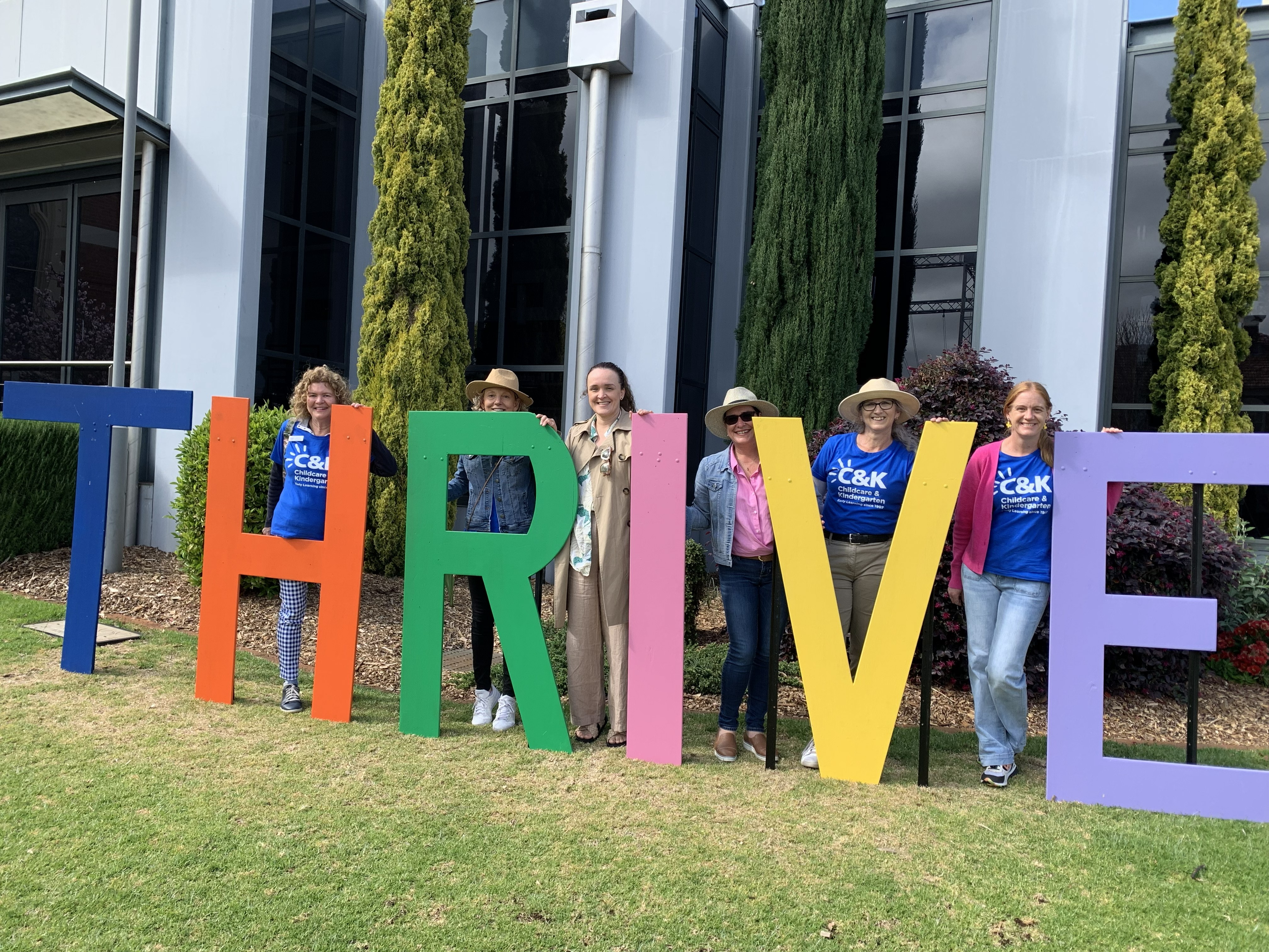 C&K Team standing with the THRIVE Festival sign