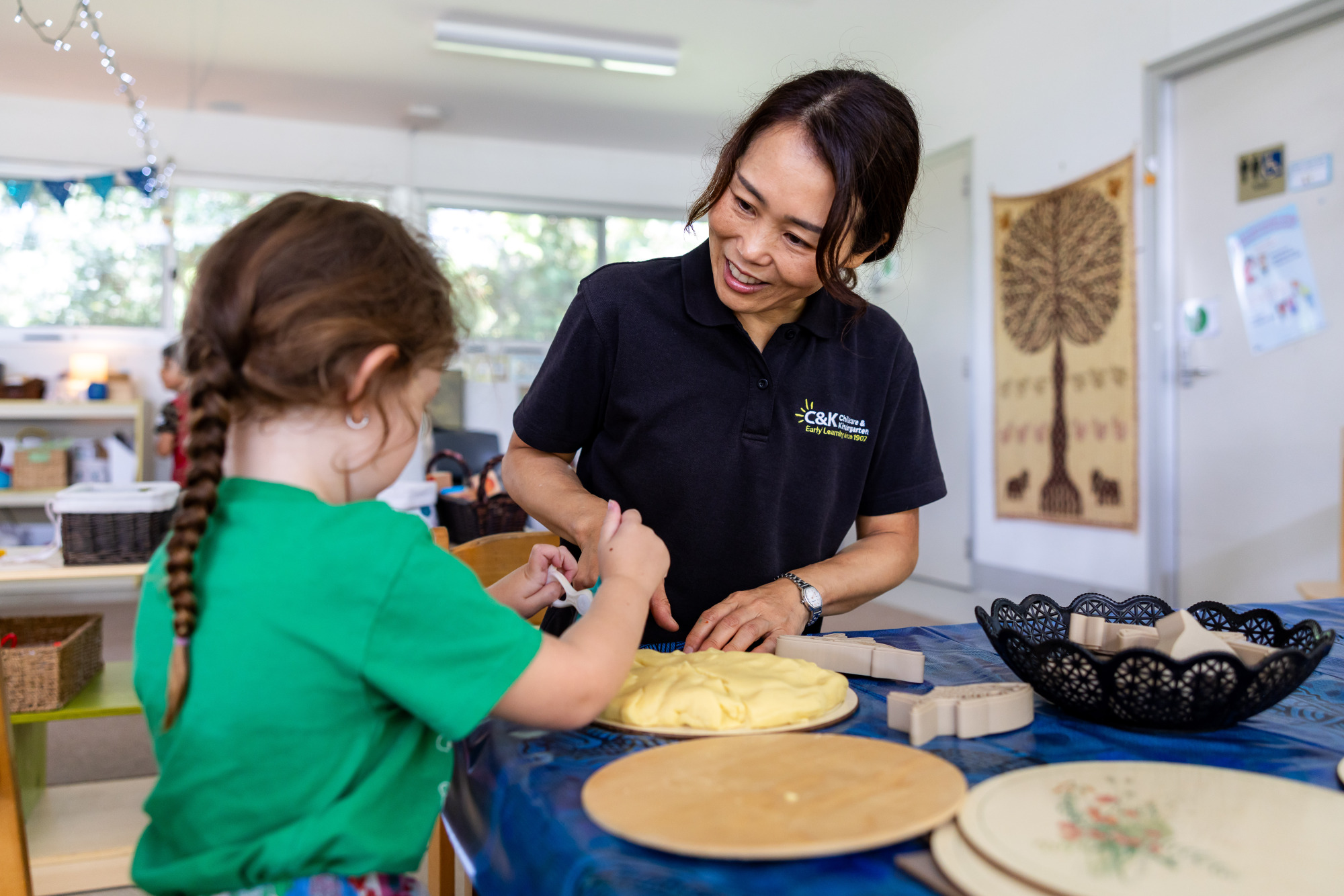 Educator and child making play dough in the holiday program