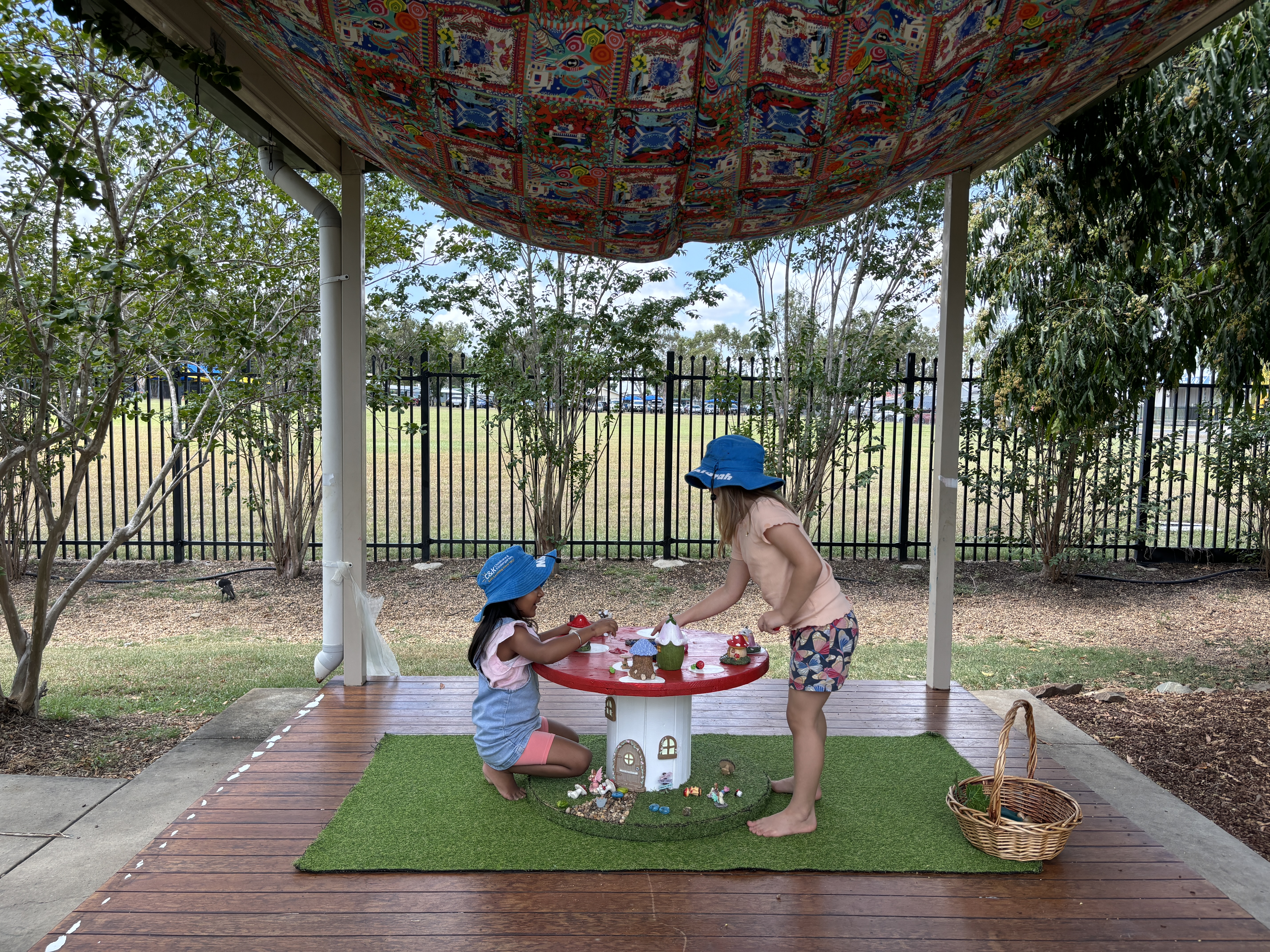 Two kindy children playing fairies outside