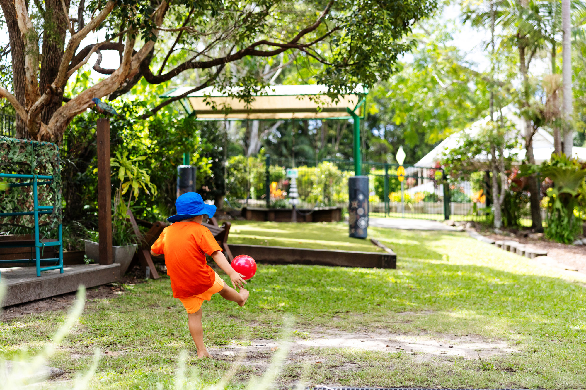 C&K Mooloolah - child kicking a ball in a large, grassy outdoor space