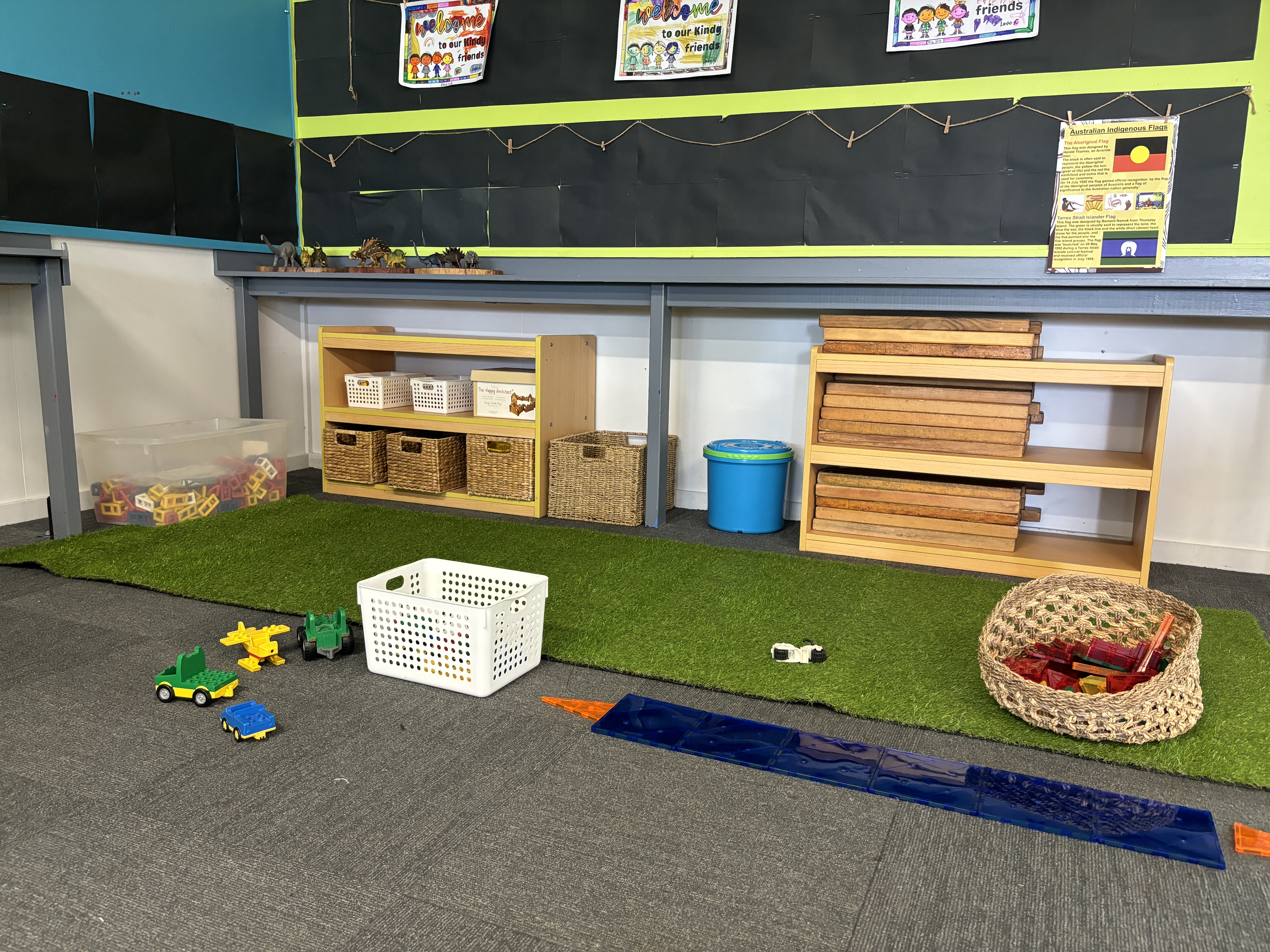 Wooden blocks, cars and magnet tiles on the floor