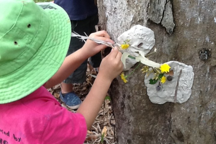 Bribie Island Kindy - child making art on a tree