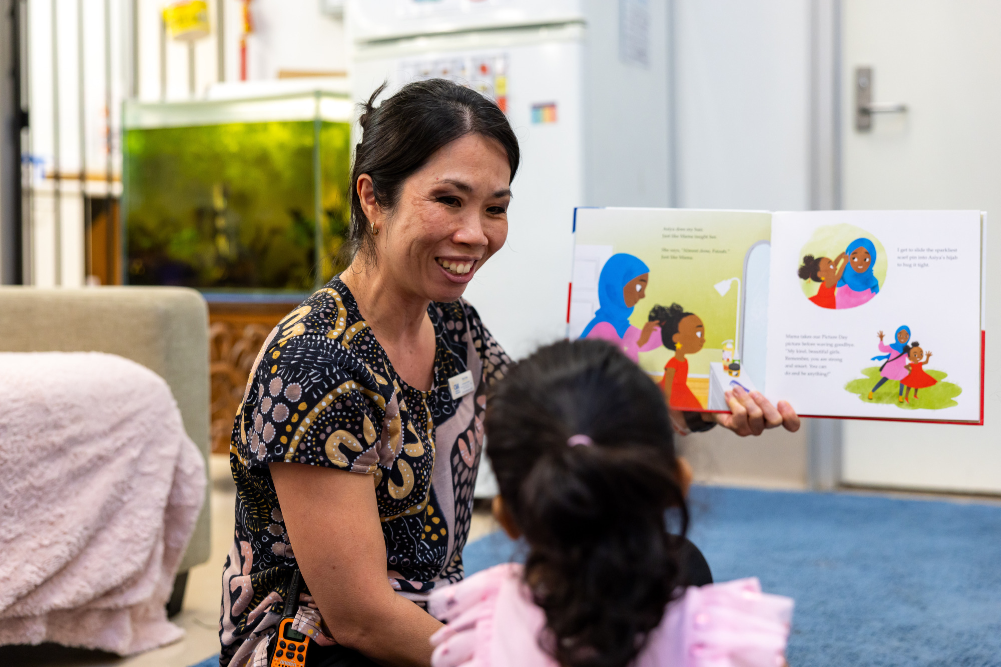 C&K Calamvale - educator reading a culturally diverse book to a child