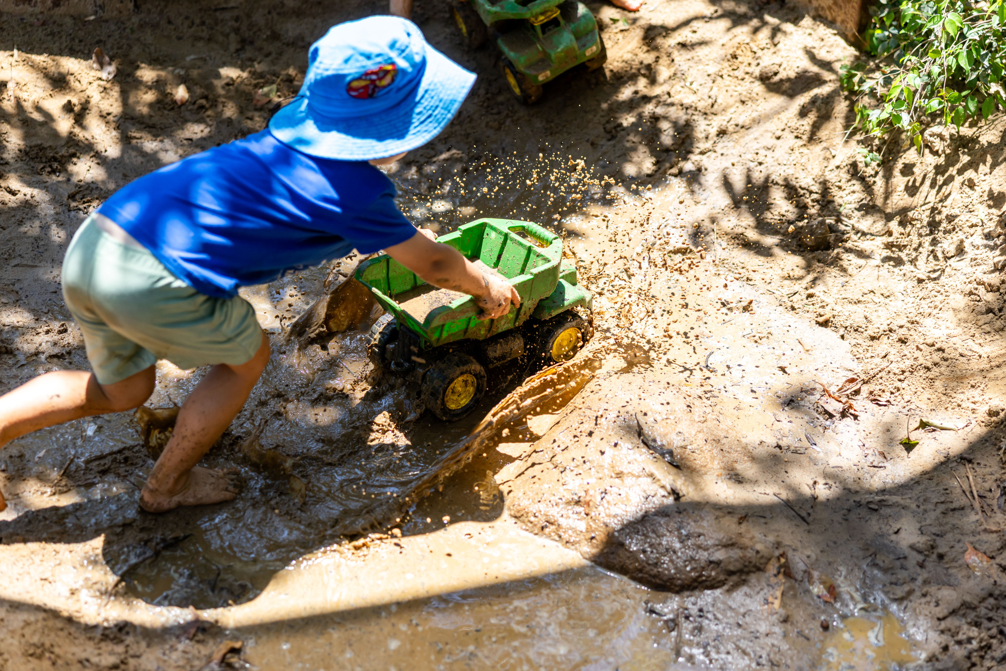 C&K Carindale - child pushing a truck through the water in the sandpit, causing the water to splash