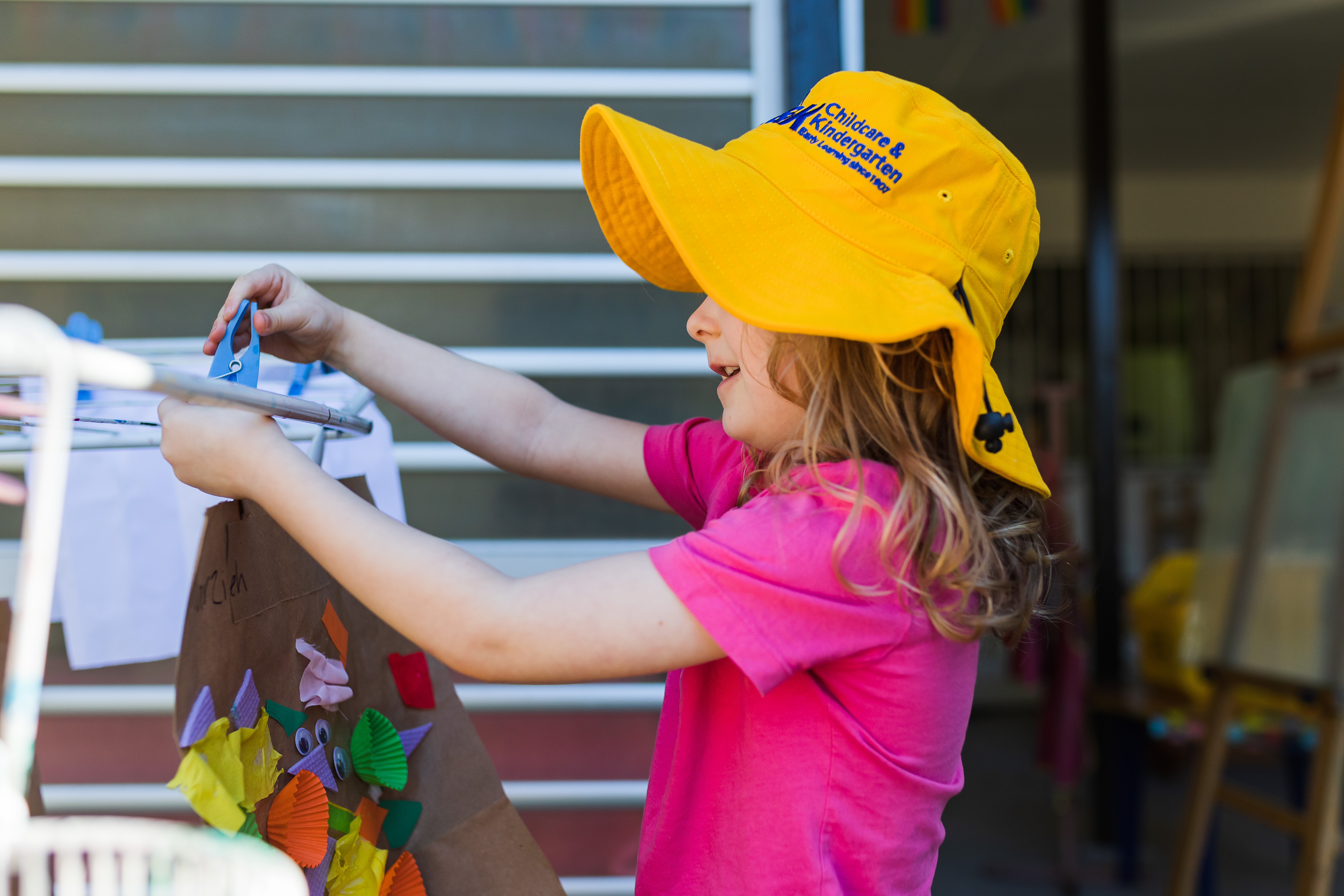 C&K Arana Hills - child proudly hanging up their artwork to dry