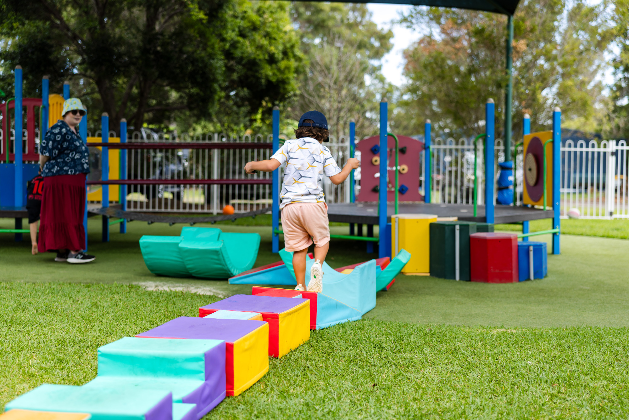 C&K Deception Bay North - child running across a soft play obstacle course to the playground fort