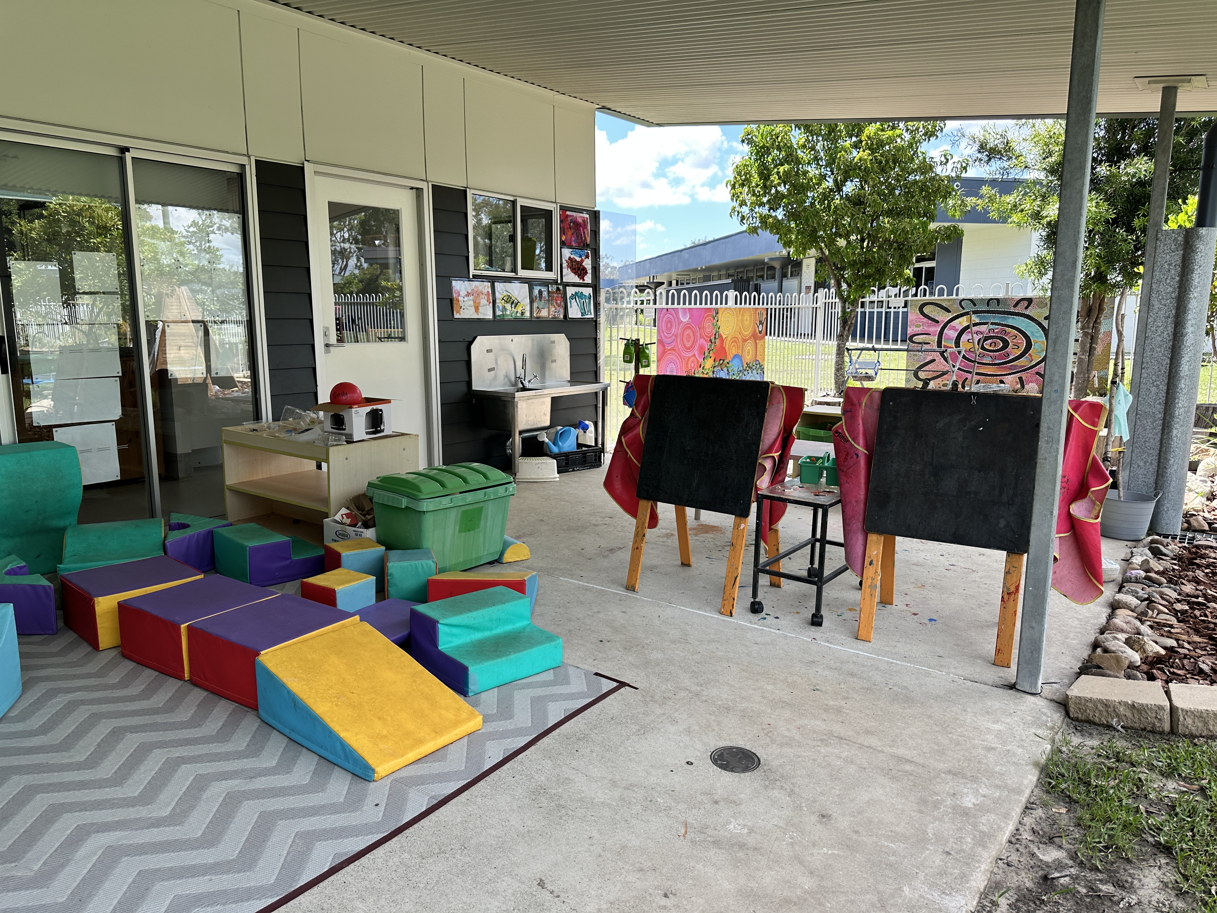 Outdoor shady verandah with soft play and art easels