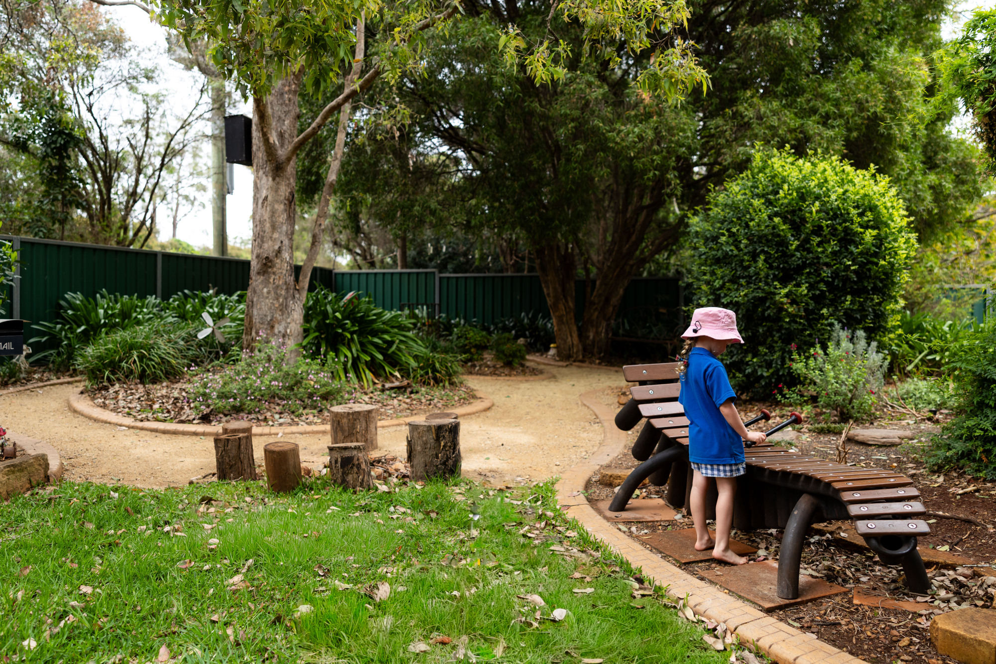 Highfields & District Kindergarten - child playing a large wooden xylophone