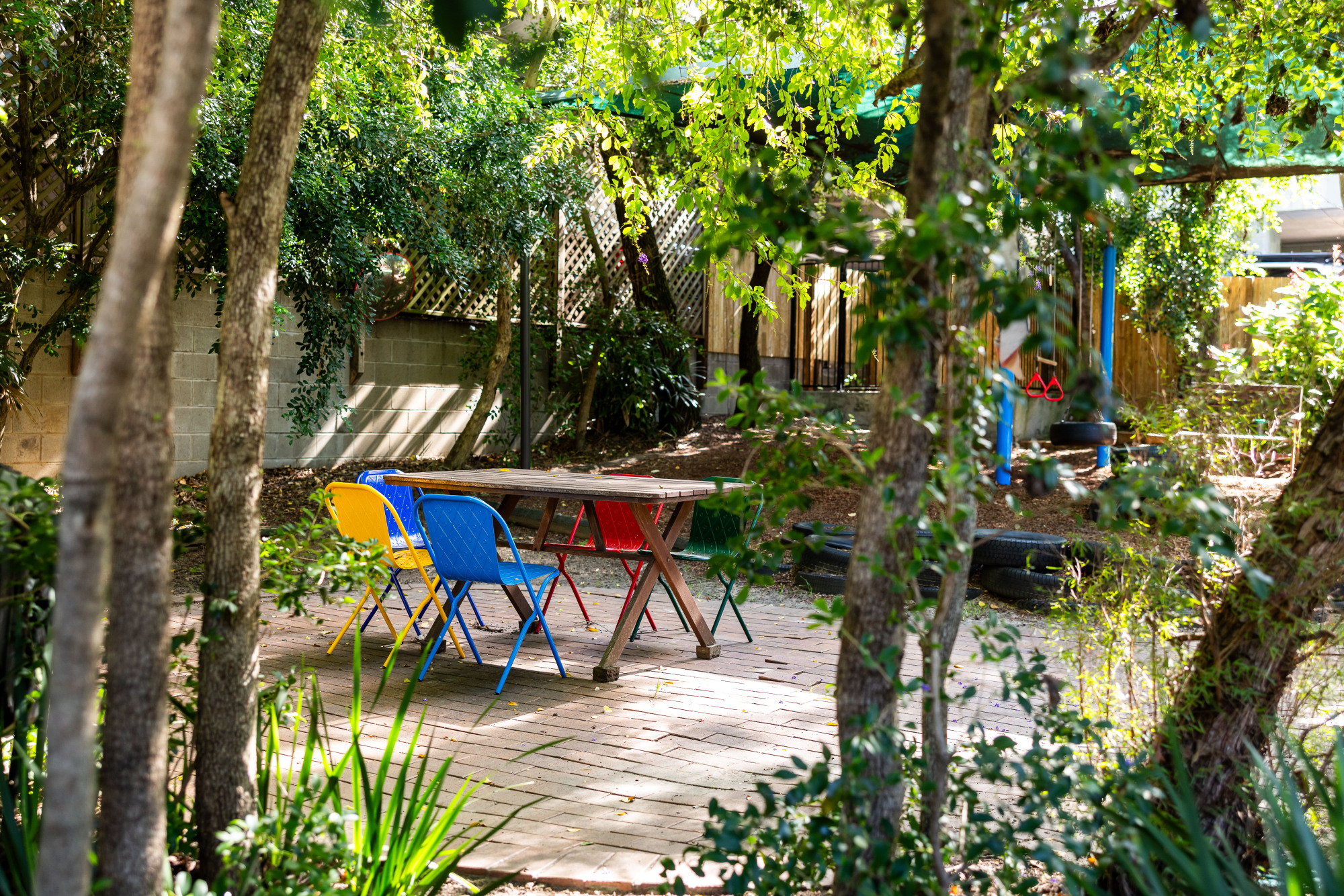 C&K Indooroopilly - table and chairs outdoors next to the playground