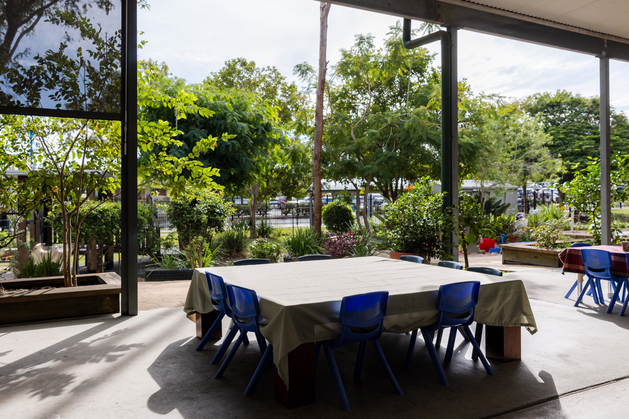 C&K Jinibara - outdoor verandah with tables and chairs, opening onto a spacious yard