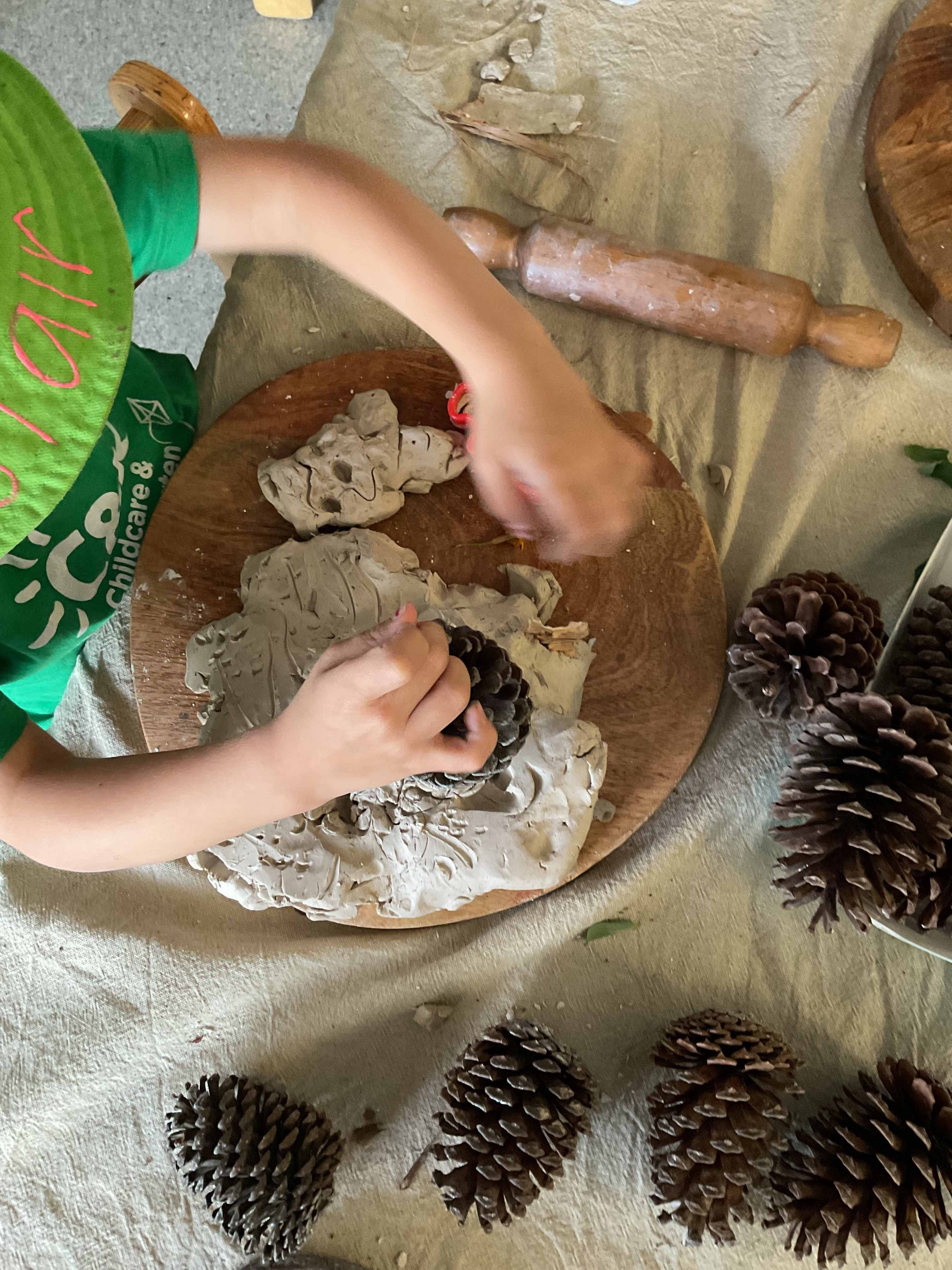Kindy child engaging in clay and nature play