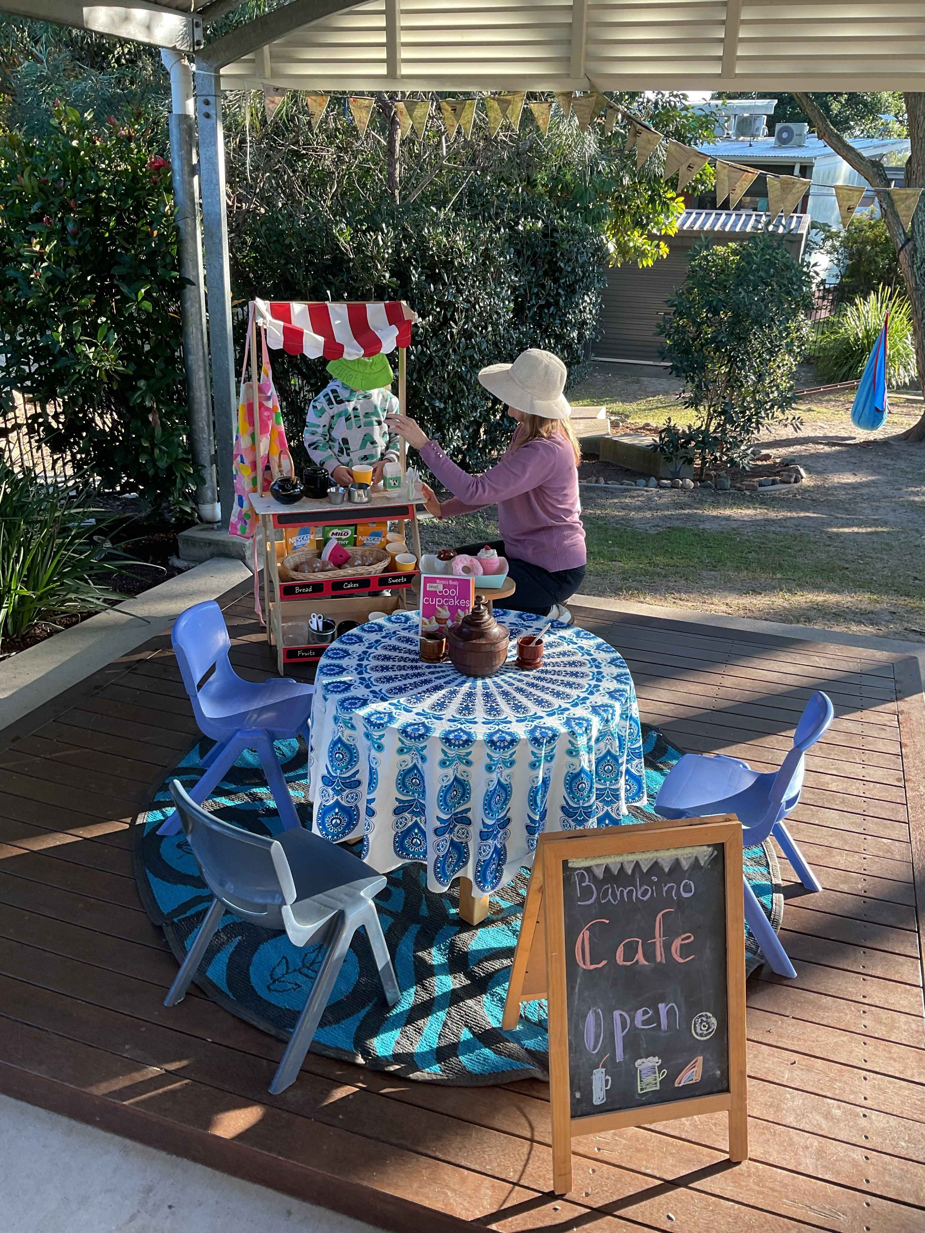 Educator and child outside playing cafes