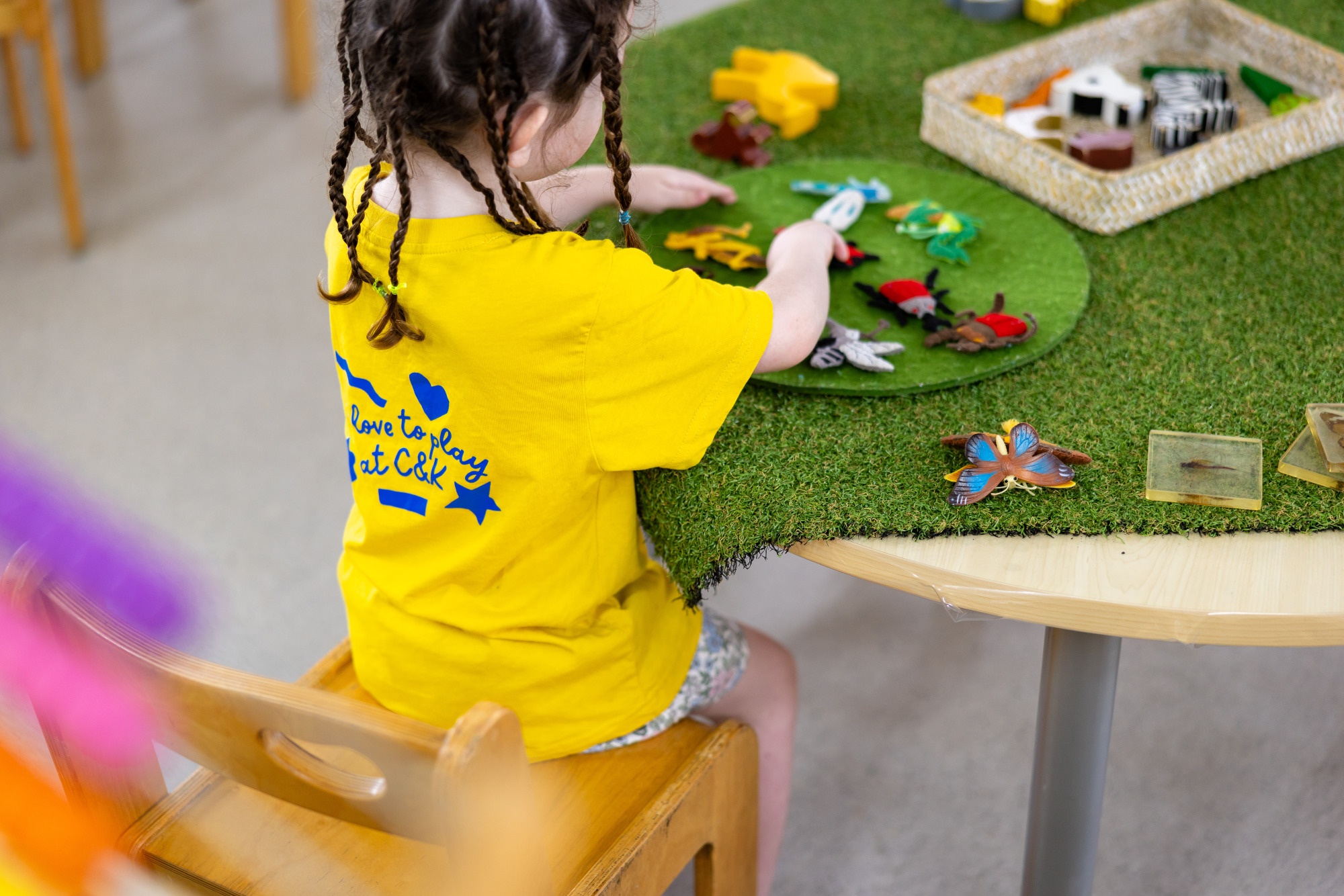 C&K Kruger - child playing with felt insects