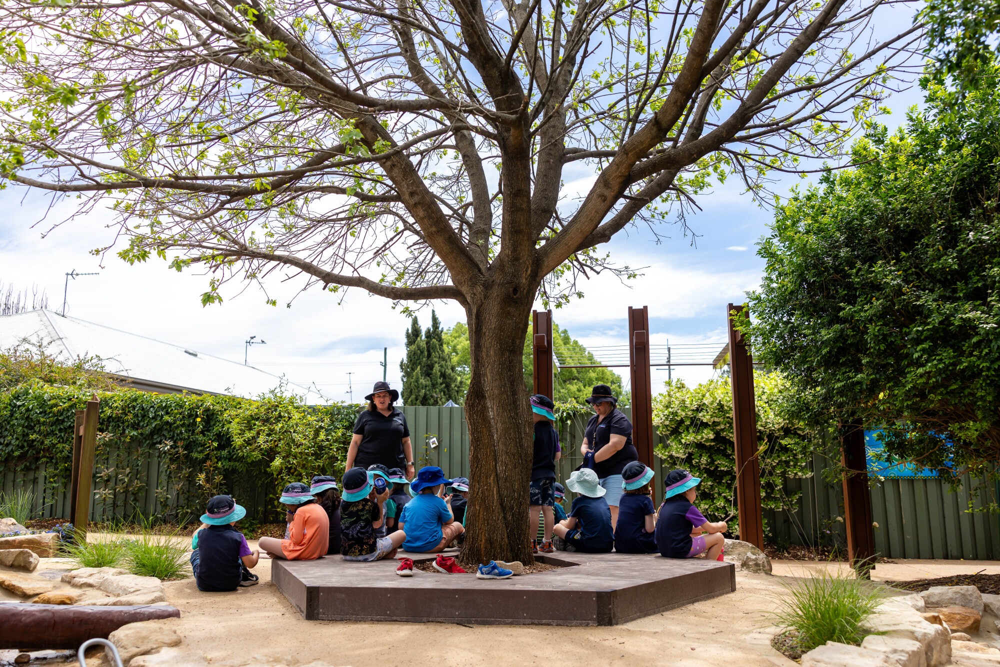 Little Miracles - educators and children gathered under a tree