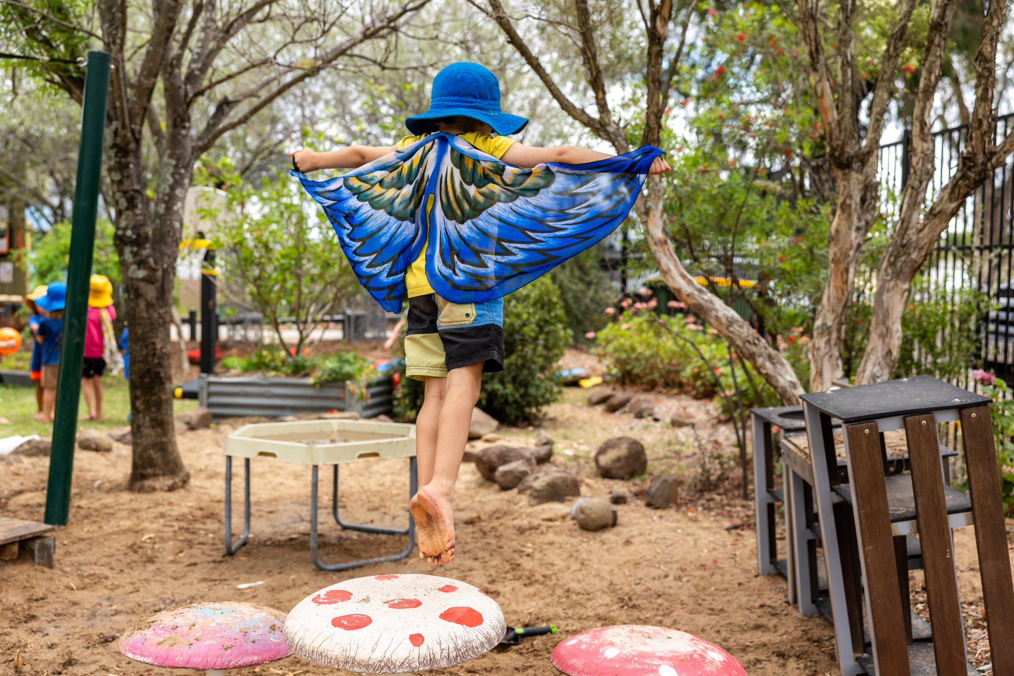 C&K Oakey - child wearing wings jumping off a toadstool shaped step