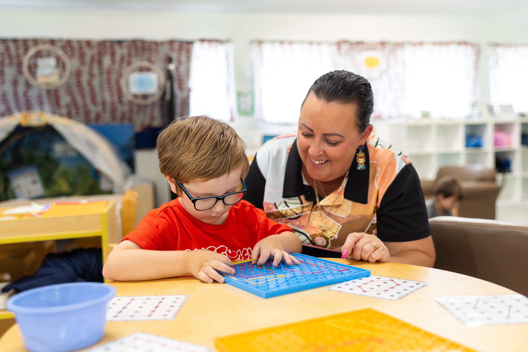 Child and educator engaged in an activity together