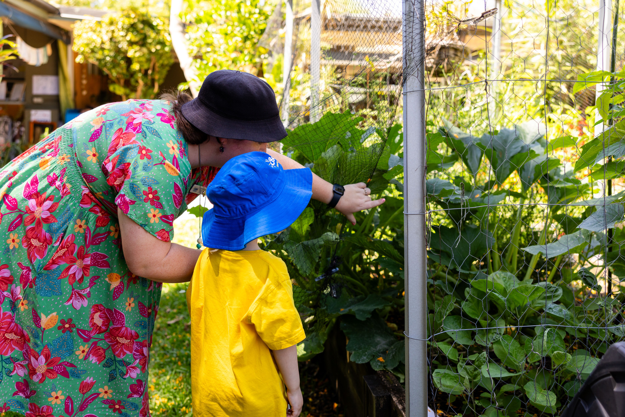 C&K Redlands - educator and child looking at the veggie garden