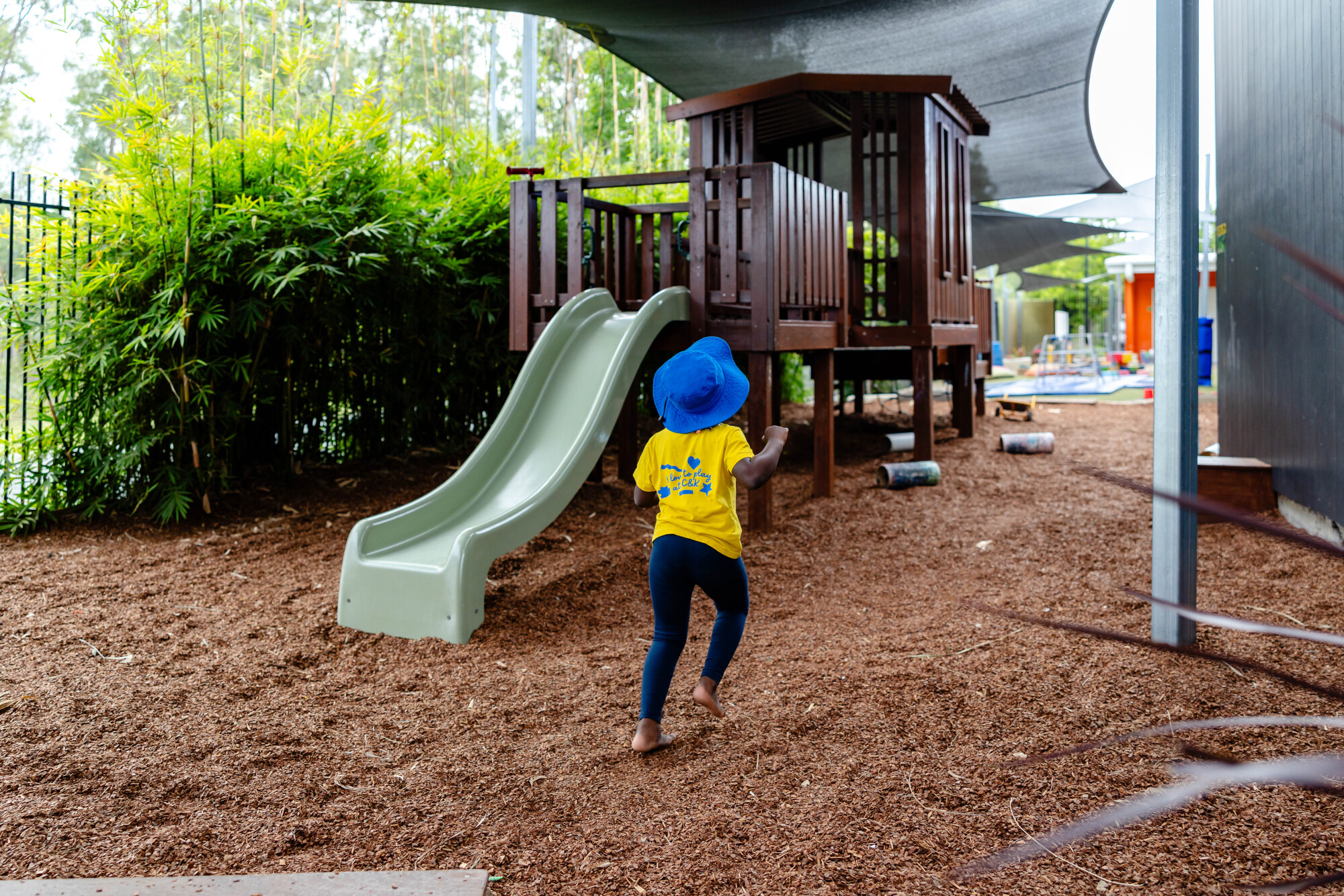 C&K Ripley - child running past the playground fort